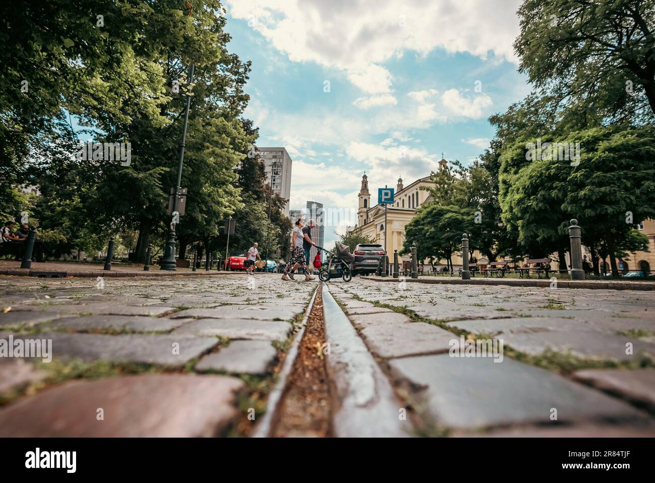 Varsovie, Pologne - 05 juillet 2022 : famille avec bébé traversant une rue pavée dans la capitale et la plus grande ville de Pologne. Banque D'Images
