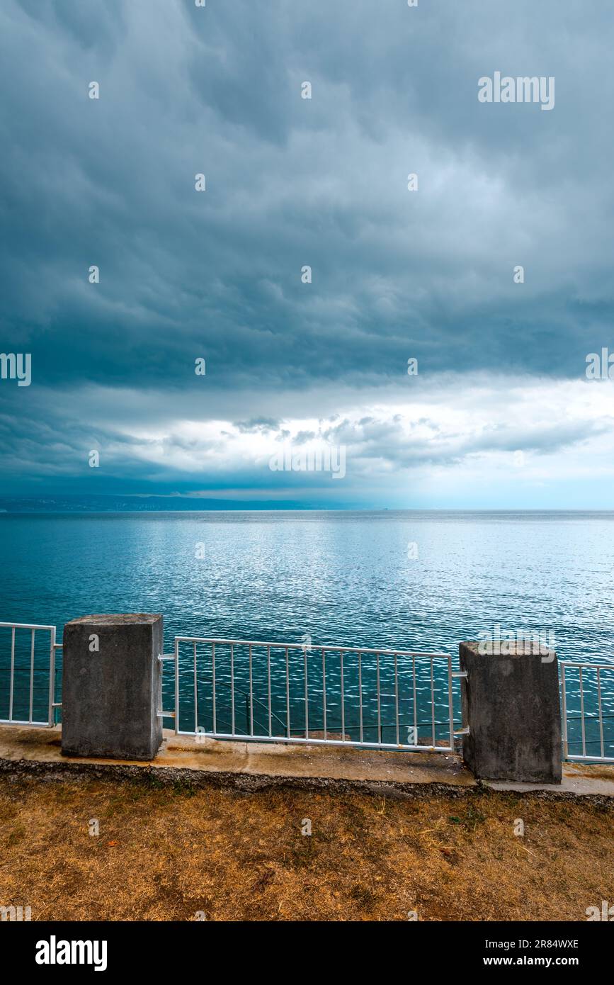 Promenade et côte de Lovran, vue sur la mer Adriatique et le golfe de Kvarner par temps froid couvert avec nuages orageux au ciel Banque D'Images