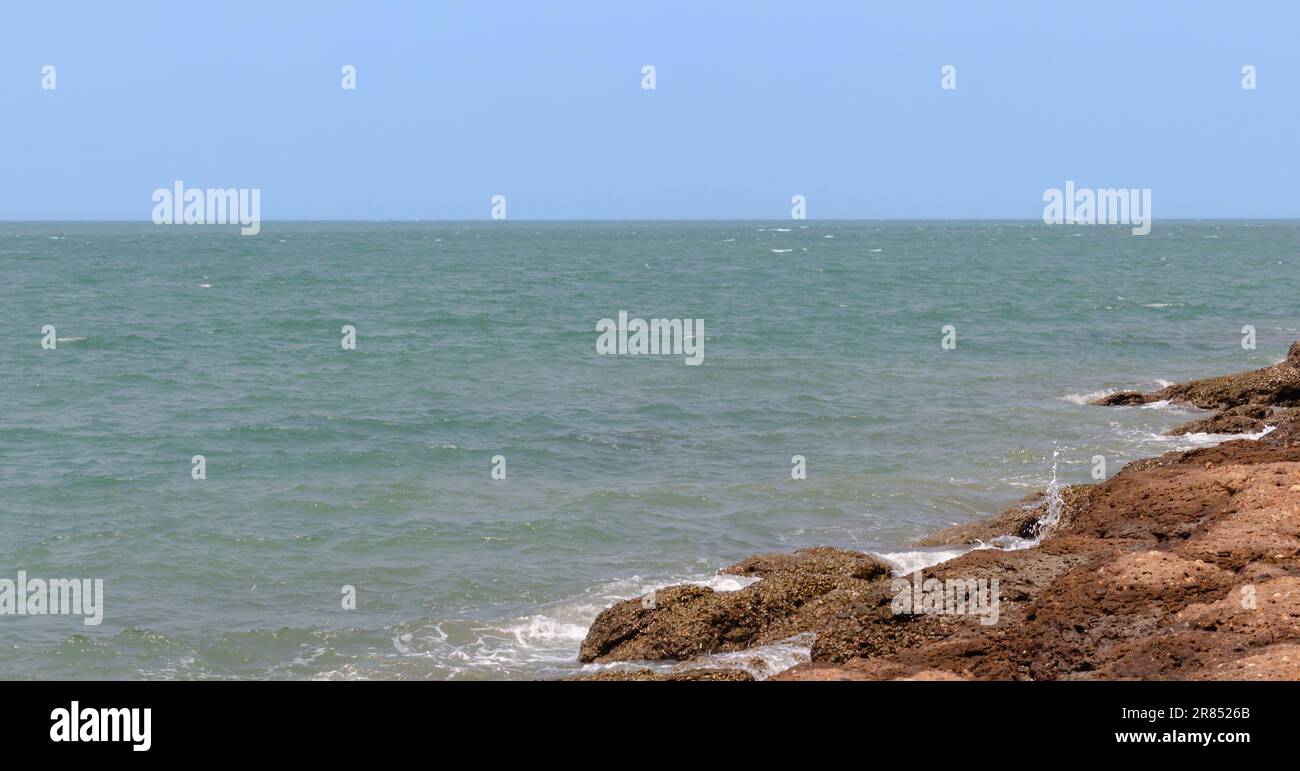 Beau ciel bleu sur mer calme. Harmonie tranquille de la mer d'une surface d'eau calme. magnifique paysage marin, mer calme, rivage rocailleux couvert de coquillages, ciel bleu Banque D'Images