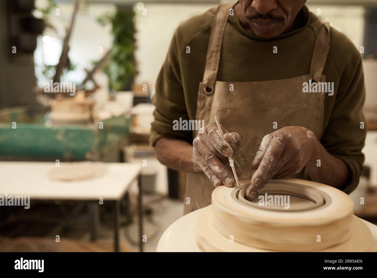 Céramiste africain façonnant l'argile dans un moule tournant sur une roue de poterie Banque D'Images