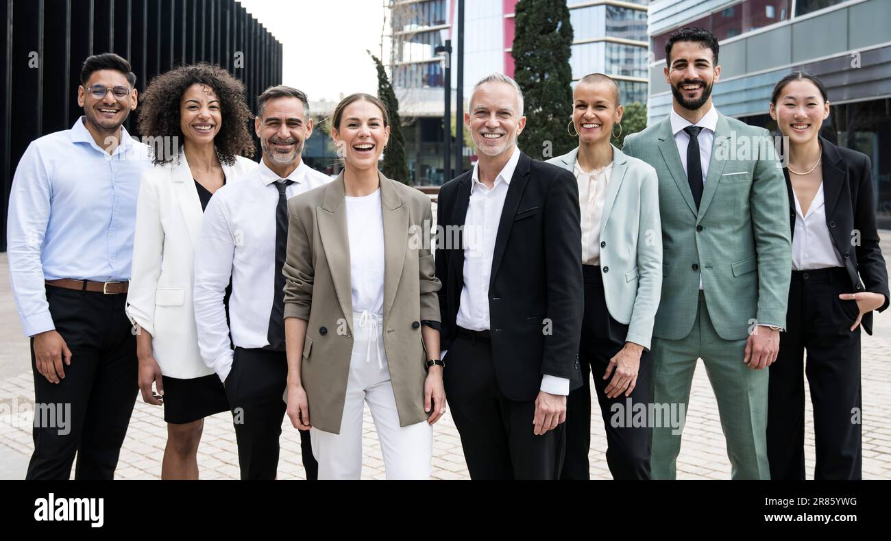 Groupe d'hommes d'affaires et de femmes d'affaires multiethniques qui se moque de la caméra. Équipe de direction multiraciale heureuse et confiante dans la rue. Banque D'Images