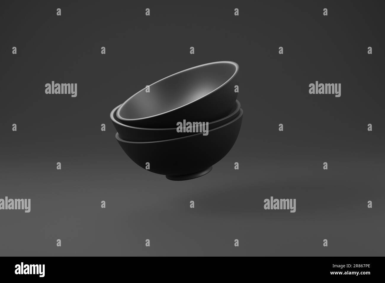 Bols noirs empilés aléatoirement sur fond sombre avec ombre en monochrome. Illustration du concept de cuisine maison, dîner et culinaire Banque D'Images