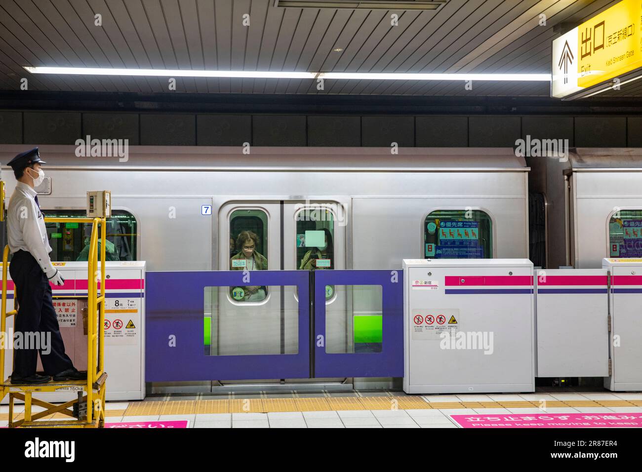 Les employés du réseau ferroviaire du métro de Tokyo gardent le train à une gare tandis que les navetteurs attendent de débarquer du train,Tokyo,Japon,2023 Banque D'Images