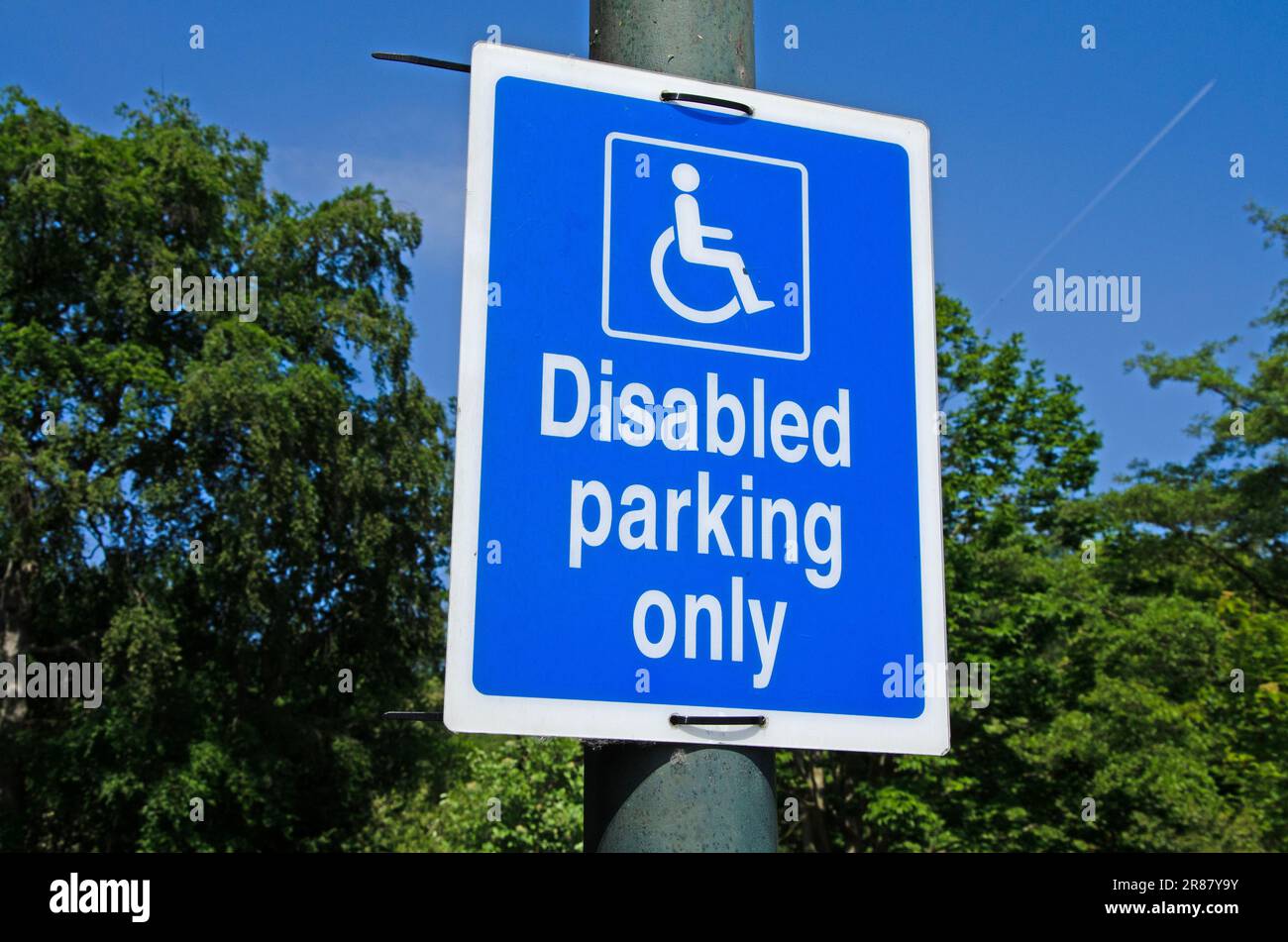 Panneau d'affichage pour le stationnement pour handicapés sur un poteau de lampe. Ciel bleu Banque D'Images