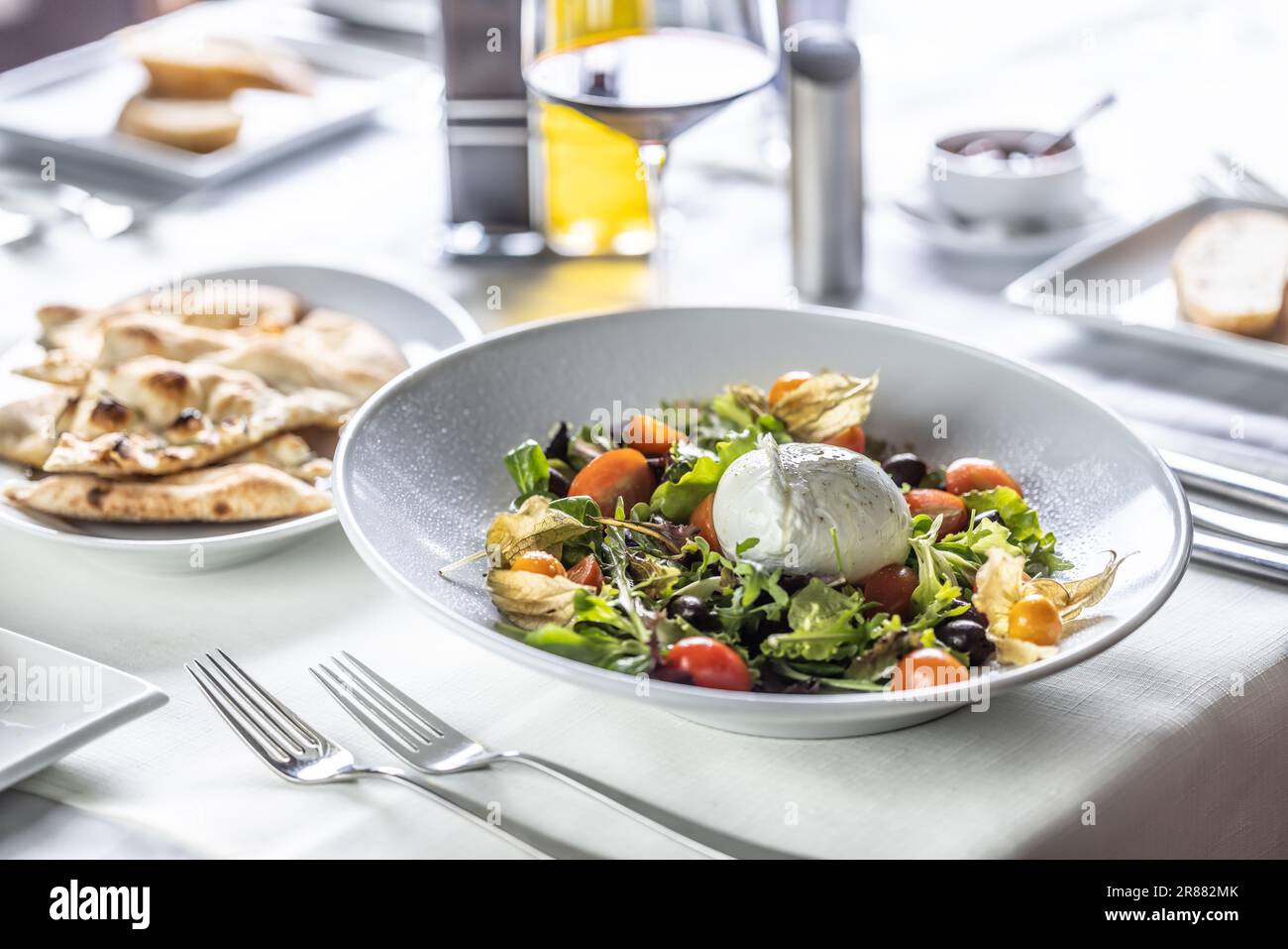 Salade de buffles servie dans un restaurant avec du vin et du pain à la pixzza. Banque D'Images