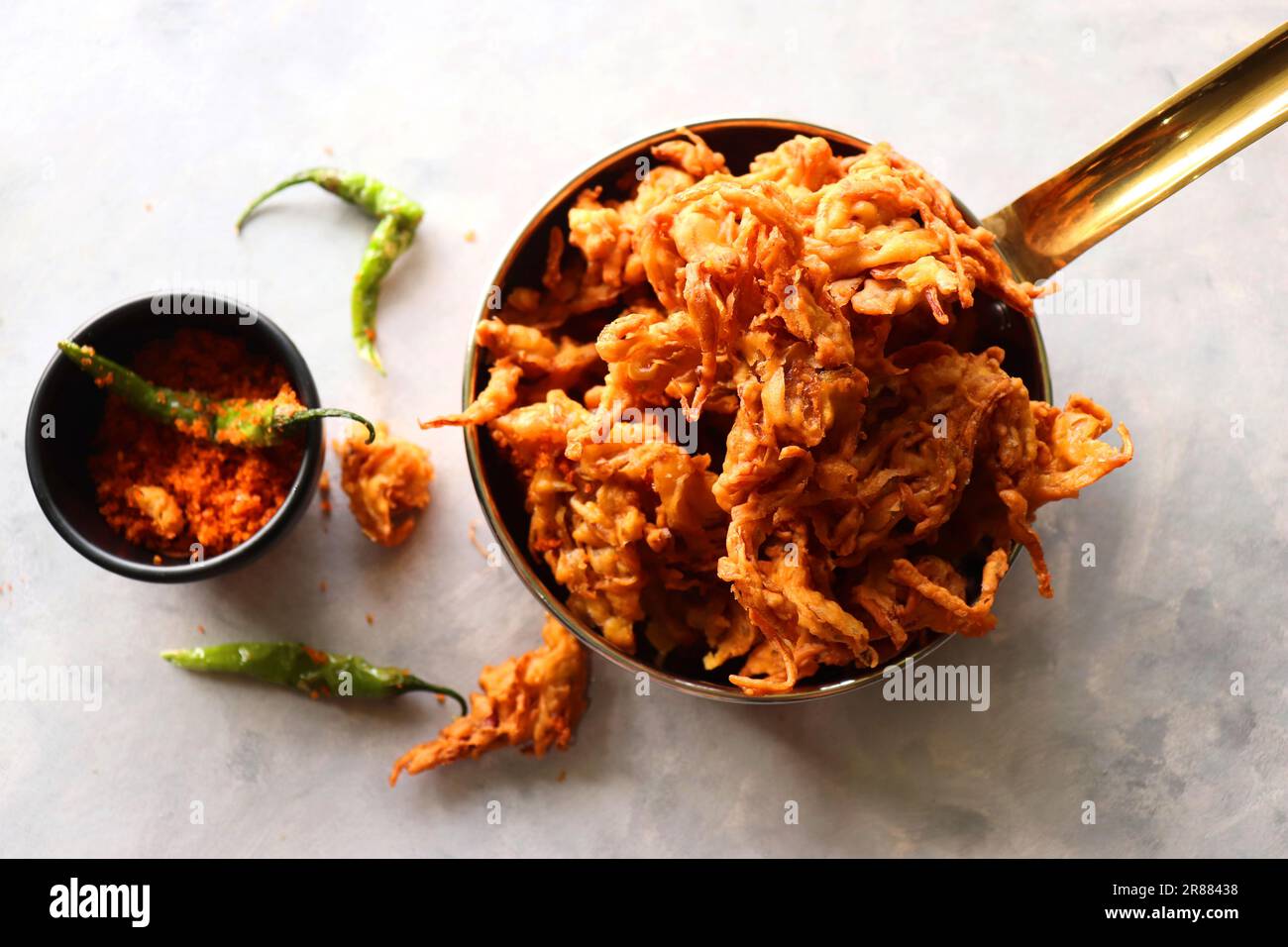 Pakode à l'oignon frit ou Pyaj ke Pakore également connu sous le nom Crispy Kanda bhaji, Bhajji, bujji. En-cas indien préféré à l'heure du thé pendant la mousson. Banque D'Images