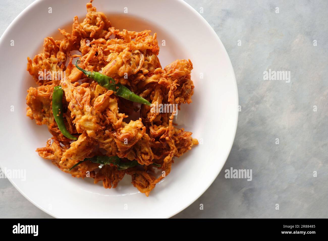 Pakode à l'oignon frit ou Pyaj ke Pakore également connu sous le nom Crispy Kanda bhaji, Bhajji, bujji. En-cas indien préféré à l'heure du thé pendant la mousson. Banque D'Images