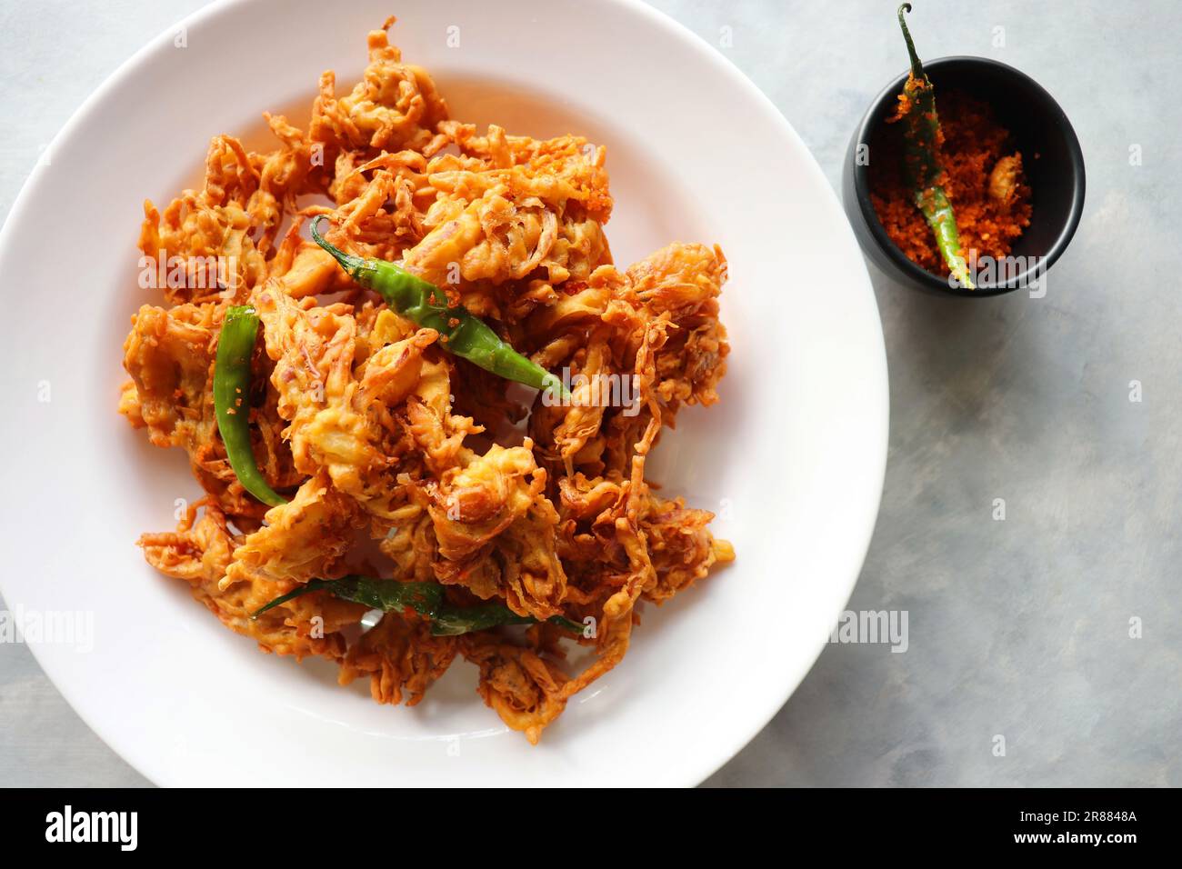 Pakode à l'oignon frit ou Pyaj ke Pakore également connu sous le nom Crispy Kanda bhaji, Bhajji, bujji. En-cas indien préféré à l'heure du thé pendant la mousson. Banque D'Images