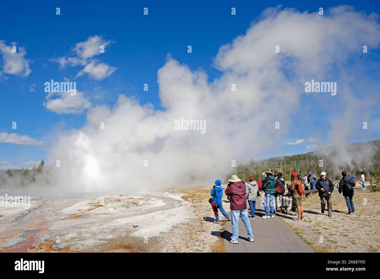 Touristes observant Daisy Geyser éruption, Upper Geyser Basin, Parc national de Yellowstone, Wyoming, Etats-Unis Banque D'Images