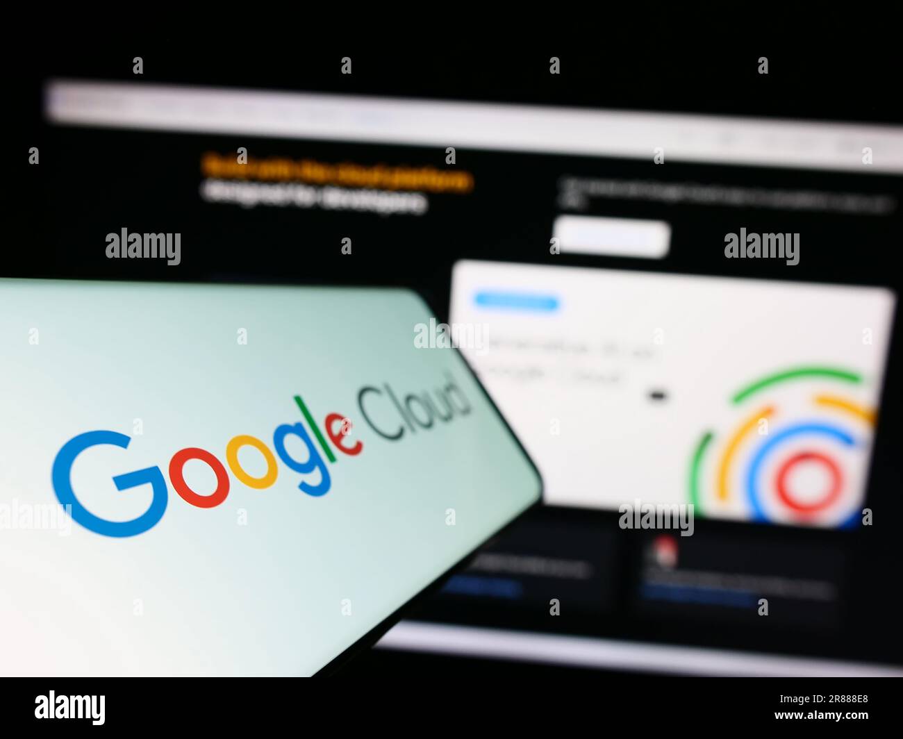 Smartphone avec logo des services informatiques Google Cloud Platform (GCP) à l'écran en face du site Web des entreprises. Mise au point à gauche de l'écran du téléphone. Banque D'Images