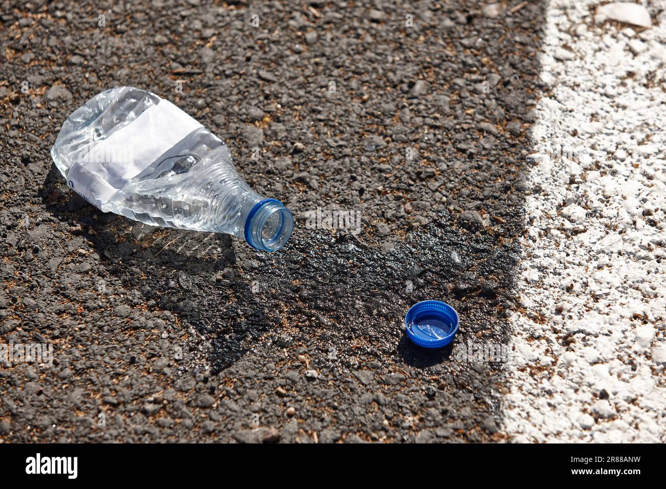 Bouteille d'eau sur l'asphalte. Déchets d'eau. Environnement Banque D'Images