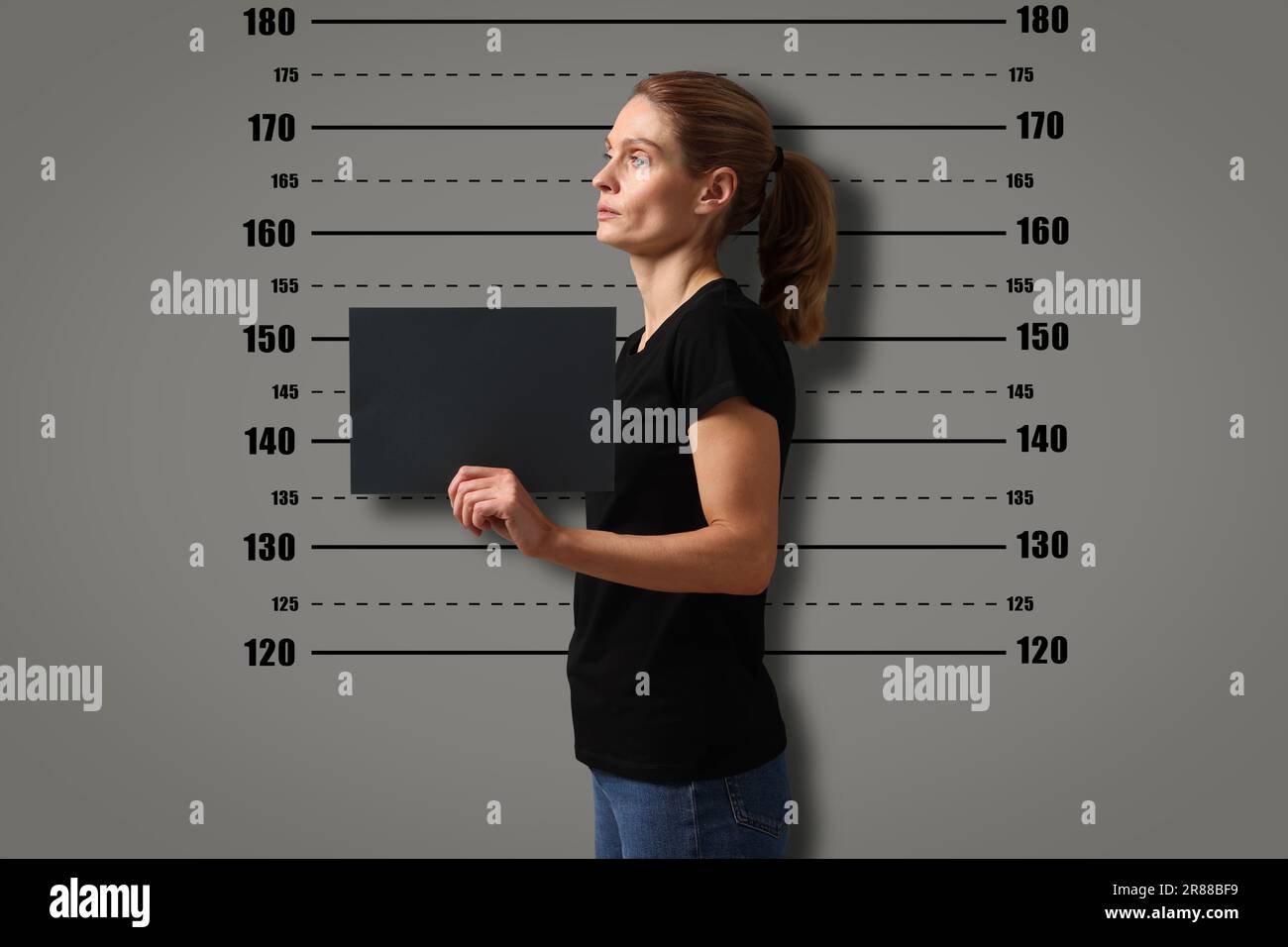 Coup de feu criminel. Femme arrêtée avec une carte vierge contre le tableau de hauteur Banque D'Images