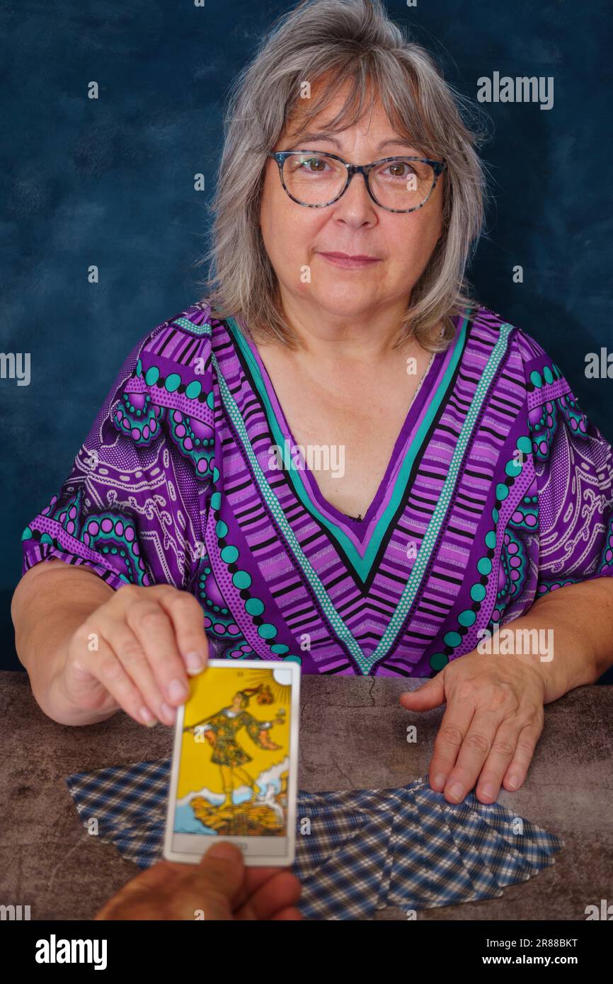 Femme âgée, casseur de fortune, donnant à un homme la carte de tarot du fou Banque D'Images