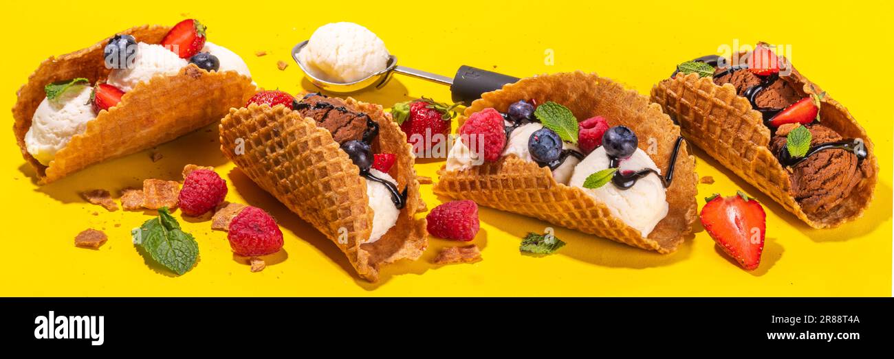 Diverses crèmes glacées au taco sucré. Coquilles de tacos à gaufrer avec glace au chocolat et à la vanille avec différents fruits, baies, garnitures Banque D'Images