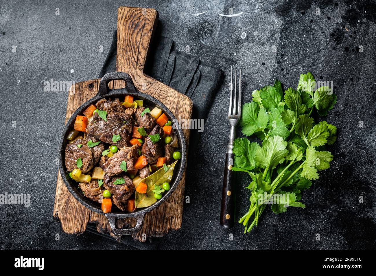 Ragoût de bœuf avec pomme de terre, carotte et herbes dans une poêle