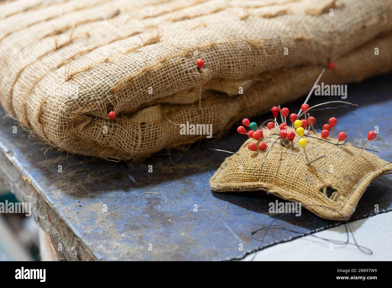 Coussin d'épingle et rembourrage moulé brut rempli de fibre végétale pour un siège dans un atelier de rembourrage, artisanat traditionnel pour créer ou réparer des meubles avec Banque D'Images