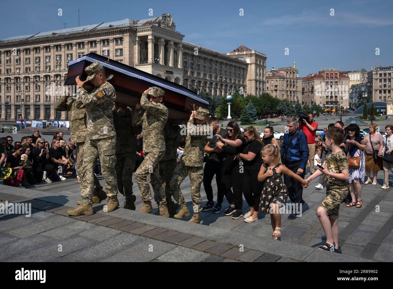 People kneel as servicemen carry the coffin of volunteer soldier Ivan Shulga, a sound producer in TV channels and musician, killed in a battle with the Russian troops near Bakhmut, during a farewell ceremony in Independence Square in Kyiv, Ukraine, Tuesday, June 20, 2023. (AP Photo/Efrem Lukatsky) Banque D'Images