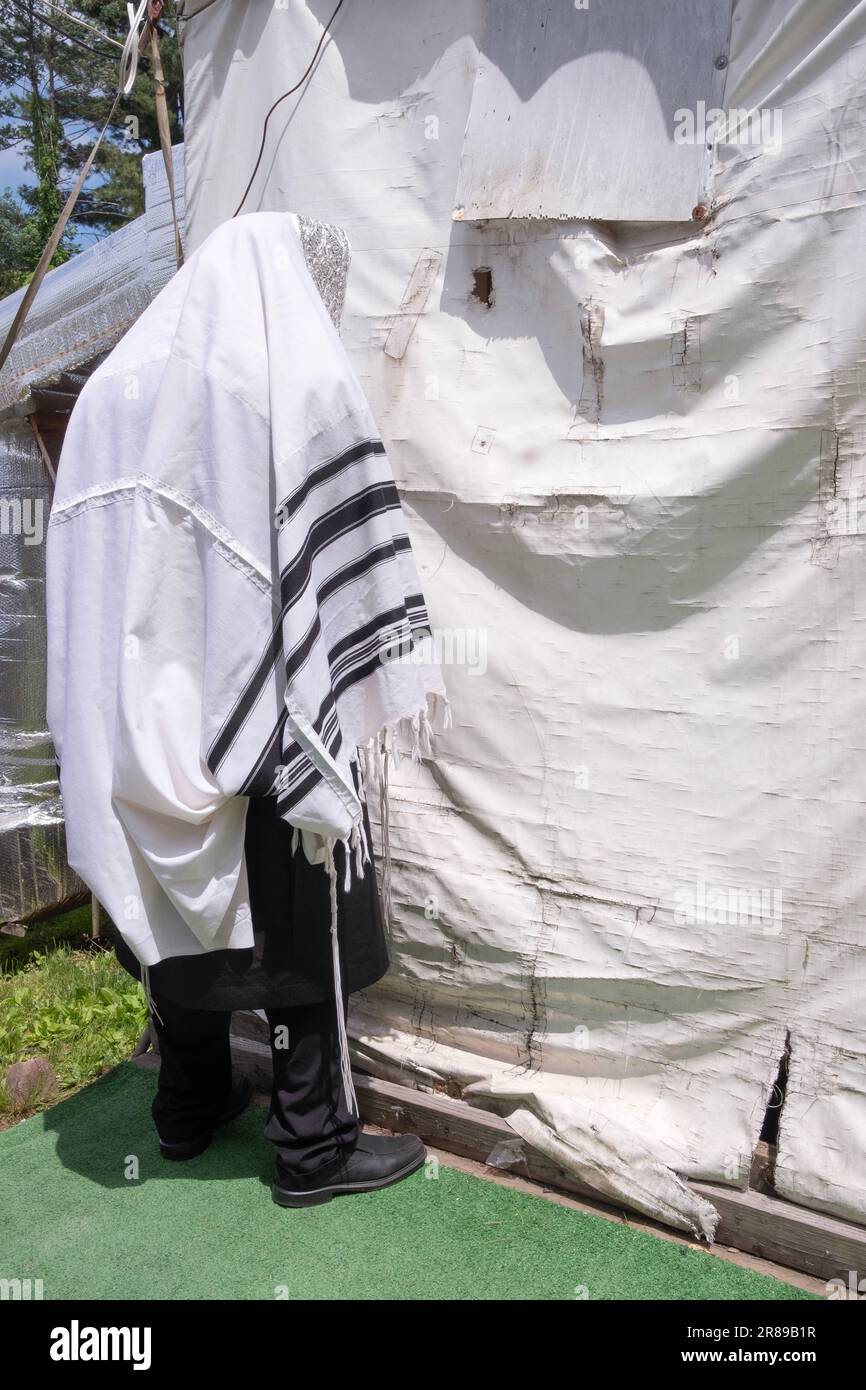 Un juif orthodoxe prie à l'extérieur devant une vieille tente utilisée pour les services. À Monsey, comté de Rockkland, New York. Banque D'Images