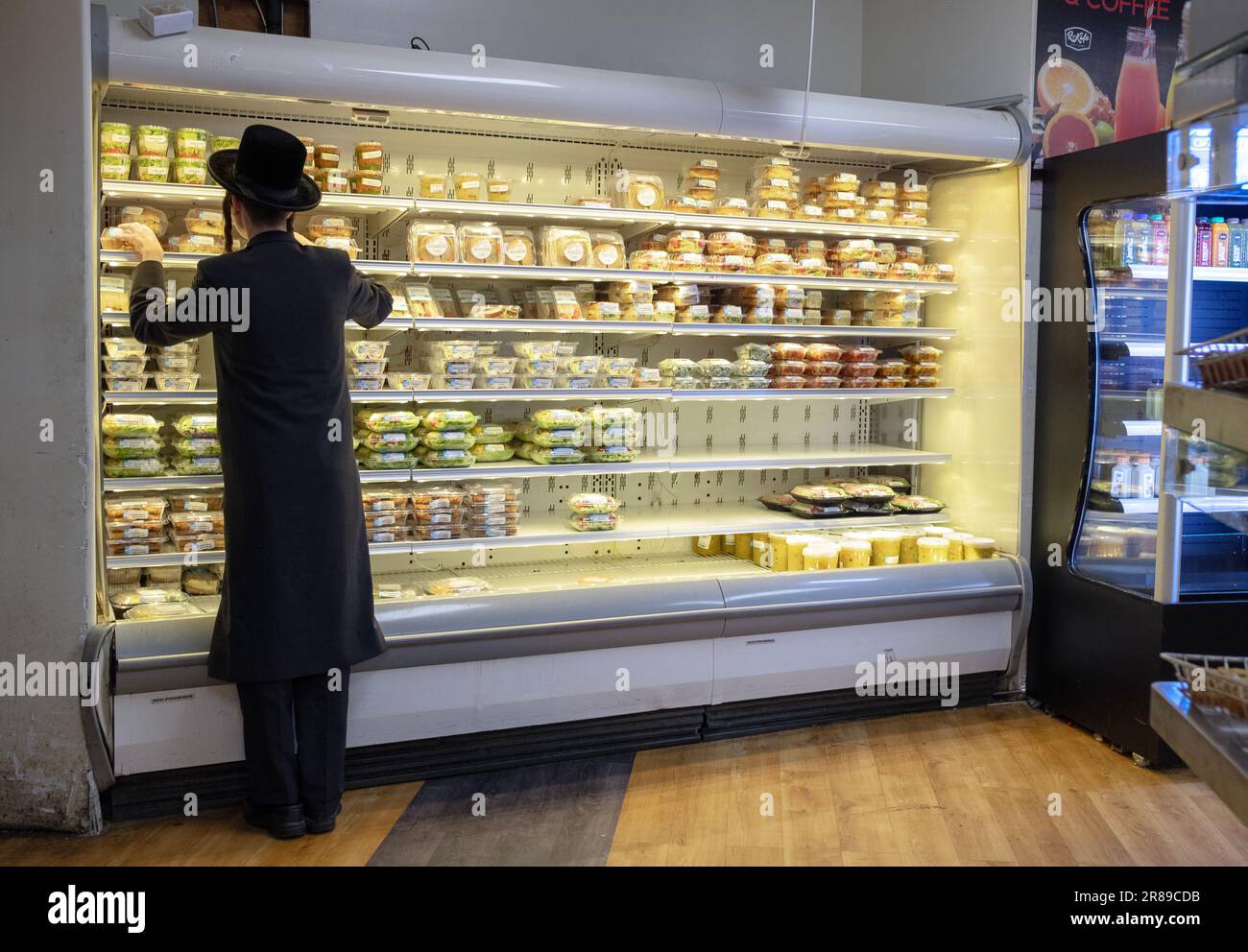 Un homme juif anonyme hassidique fait des courses de nourriture préparée au marché casher de Rockland à Monsey, New York. Banque D'Images