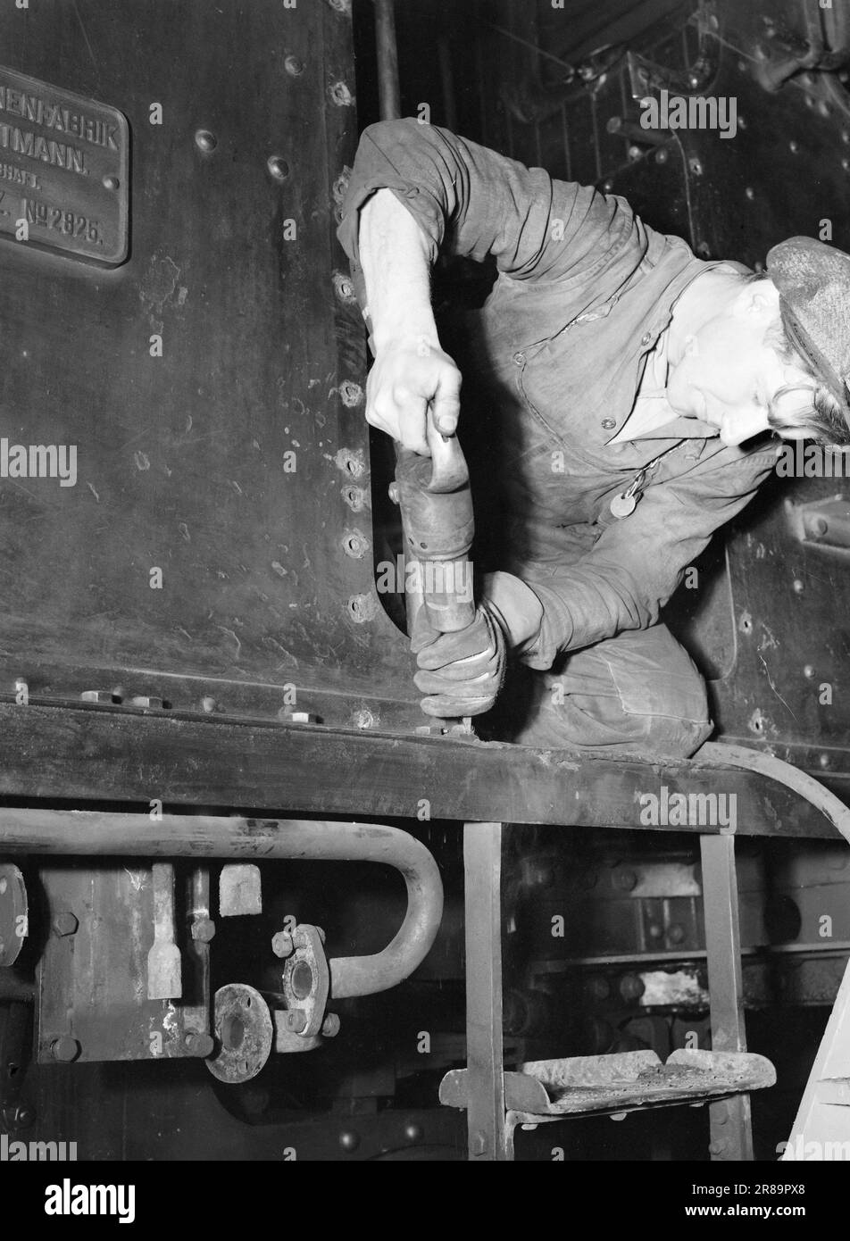 Actuel 21-3-1947: Gradud Railway WorkshopThe Dead Draft bts Five Years of occupation a fait un lourd tribut sur toutes sortes de matériel ferroviaire. Les Allemands n'ont pas exactement de locomotives et de wagons de rechange, et les pièces de rechange étaient extrêmement difficiles à obtenir. C'est le problème de la puissance de traction qui a principalement empêché le chemin de fer de desservir ceux qui voyagent en train comme il l'aurait voulu. La locomotive est démontée. Gunnar Kristiansen retire les anciennes vis à l'aide d'un ciseau à air. Toutes les différentes pièces sont ensuite envoyées par un lave-linge. Photo : Th. Skotaam / Aktuell / NTB *** Banque D'Images