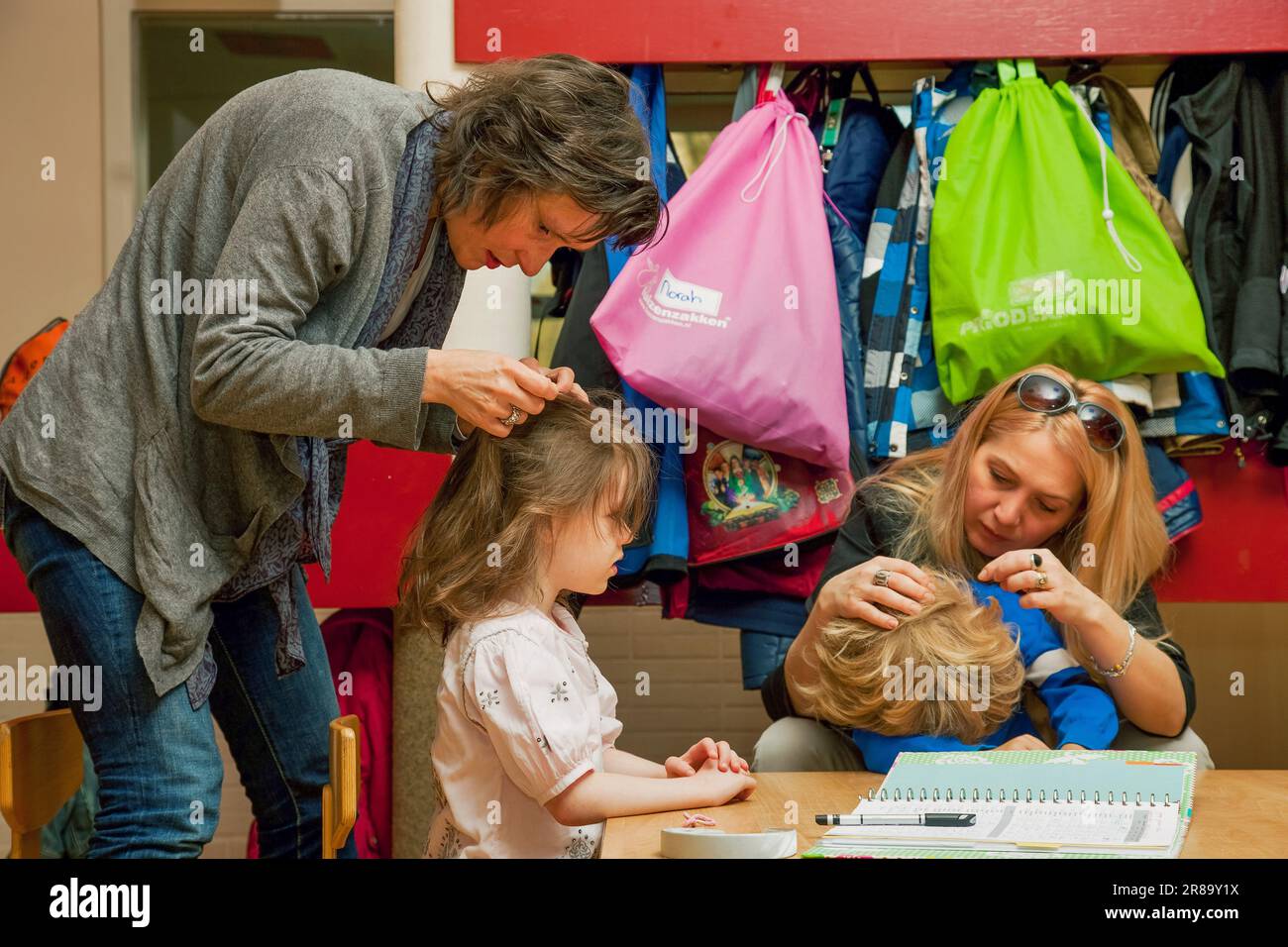 Pays-Bas, Arnhem. École primaire. Les mères sont à la recherche de puces dans les cheveux des écoliers pendant l'école. Banque D'Images