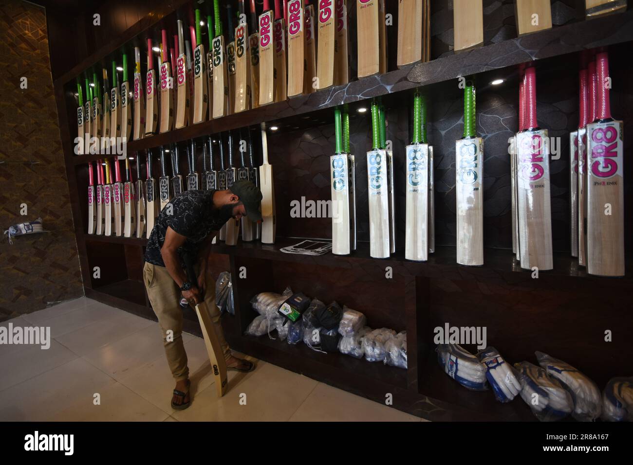 Un travailleur pose une protection en caoutchouc sur la poignée de GR8 chauves-souris de cricket dans une unité de fabrication de Sangam, à environ 38 kilomètres au sud de Srinagar, la capitale estivale du Cachemire indien, le 16 juin 2023. Les fabricants de chauves-souris du Cachemire ont reçu une commande pour que les chauves-souris soient utilisées lors de la coupe du monde 2023 One Day International (ODI); ils ont même déjà reçu une commande pour 10 chauves-souris pour la coupe du monde Twenty20 (T20) en 2022. Seulement deux types de chauves-souris sont utilisés dans le cricket dans le monde entier - le saule anglais et le saule de Kashmiri - et tandis que les prix du saule anglais sont beaucoup plus élevés que ceux faits de Willow de Cachemire et Banque D'Images