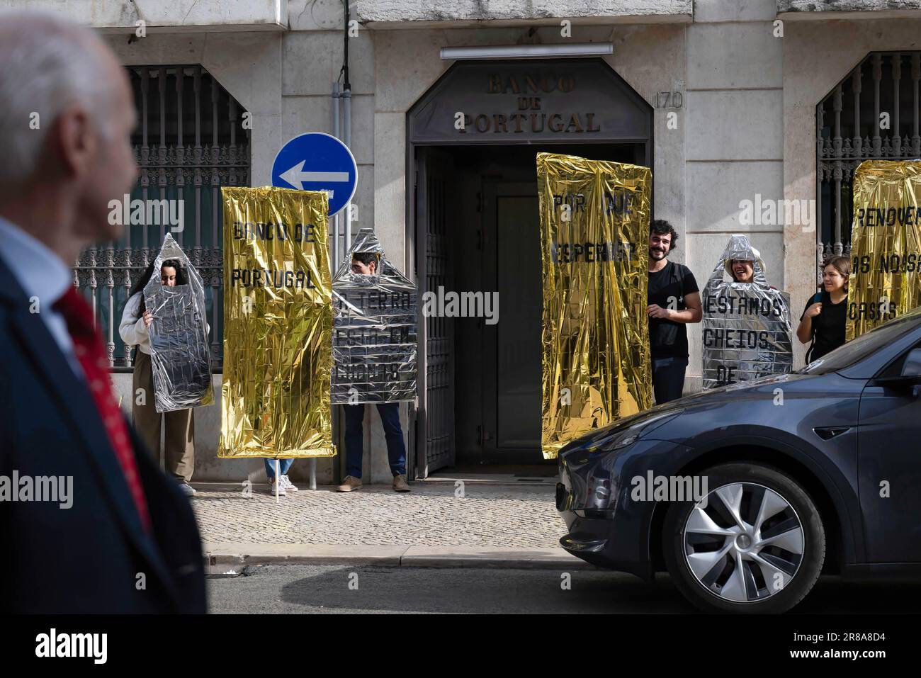 Des militants habillés de maisons exécutent une action visuelle lors d'une manifestation devant la Banque du Portugal à Lisbonne. L'association ZÉRO lance une initiative de protestation dans le cadre d'une action visant à inviter la Banque centrale à promouvoir des mesures fortes et efficaces pour soutenir les objectifs climatiques du Portugal et de l'Union européenne. Cette action implique 12 organisations non gouvernementales internationales dans le cadre de la campagne européenne visant à faire pression sur le Conseil des gouverneurs de la Banque centrale européenne pour qu'il applique des taux d'intérêt réduits pour les rénovations éconergétiques. (Photo de Jorge Castellanos/SOPA Images/S. Banque D'Images