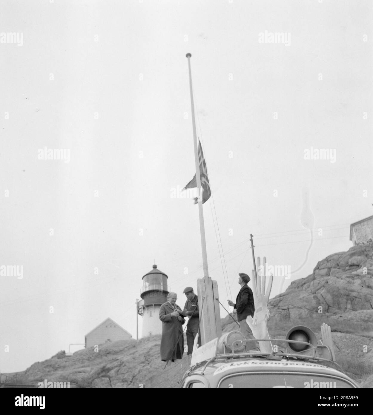 Actuel 48-10-1960 : qui veut une voiture gratuite? La course des doigts chanceux a arrondi Lindesnes dans des gales fraîches et avec un grand succès. La Norvège occidentale et une grande partie de la bande côtière douce sont maintenant équipées de punaises noires. La voiture à l'extrémité sud de la Norvège, Lindesnes. Le maître de phare Reinart Rasmussen lève le drapeau pour accueillir les personnes chanceux de doigt tandis que Mme Ingebjørg (à gauche) donne son empreinte digitale à notre employé détaché (au centre). Il n'y a pas longtemps, la voiture publique de lykkefinger était à la Nordkapp - la voiture a fonctionné ainsi que le lykkefingerløpet tout le chemin. Photo: Bjørn Bjørnsen Banque D'Images