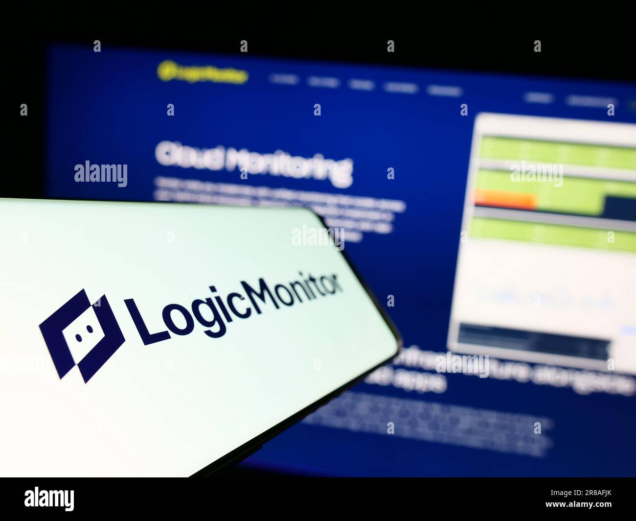 Téléphone mobile avec logo de la société américaine de surveillance LogicMonitor Inc. À l'écran devant le site Web d'affaires. Mise au point à gauche de l'écran du téléphone. Banque D'Images