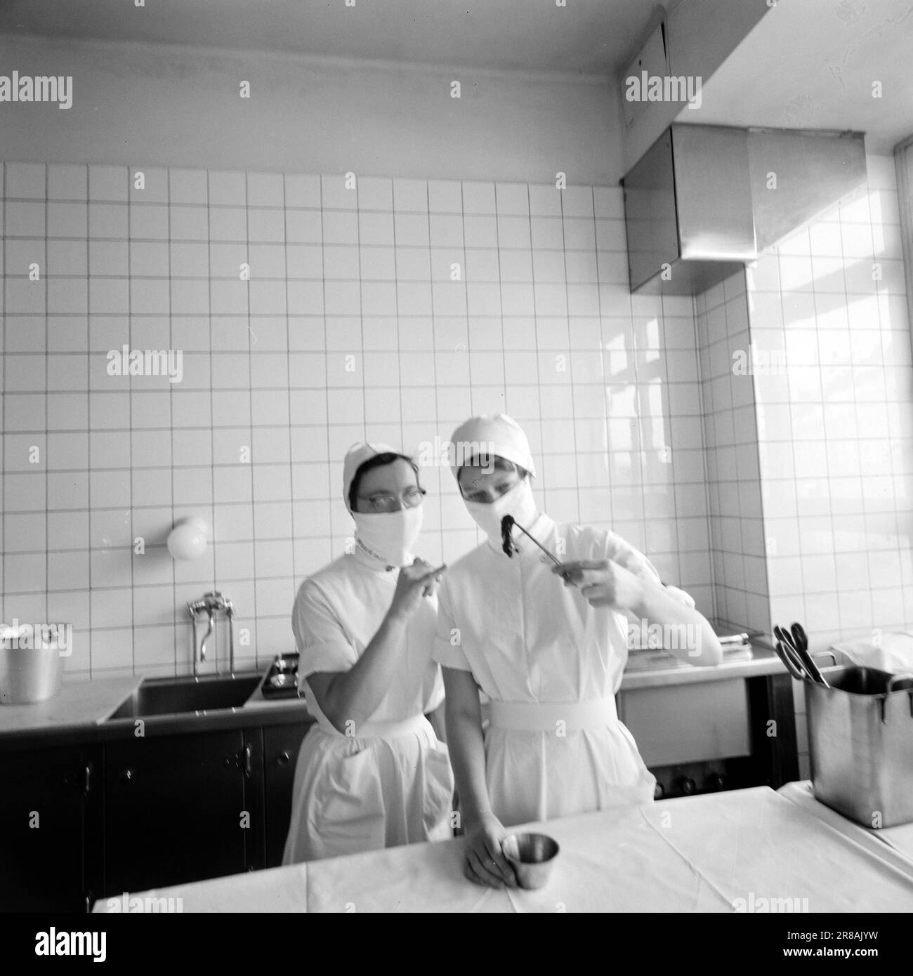 Courant 16-9-1960: Un aperçu dans le cerveau pendant cinq heures le chirurgien se tenait près de la tête du patient. Deuxième par seconde les heures tickées par - et pas l'un d'entre eux pouvait se reposer, parce qu'un homme lui avait confié sa vie. Les employés d'Aktuell ont été autorisés à suivre l'opération qui a été effectuée à Rikshospitalet à Oslo. Soeur Louise (à gauche) et soeur Anne regardent la partie malade enlevée du cerveau qui contient la malformation des vaisseaux sanguins. Photo: Aage Storløkken / Aktuell / NTB ***PHOTO NON TRAITÉE*** Banque D'Images
