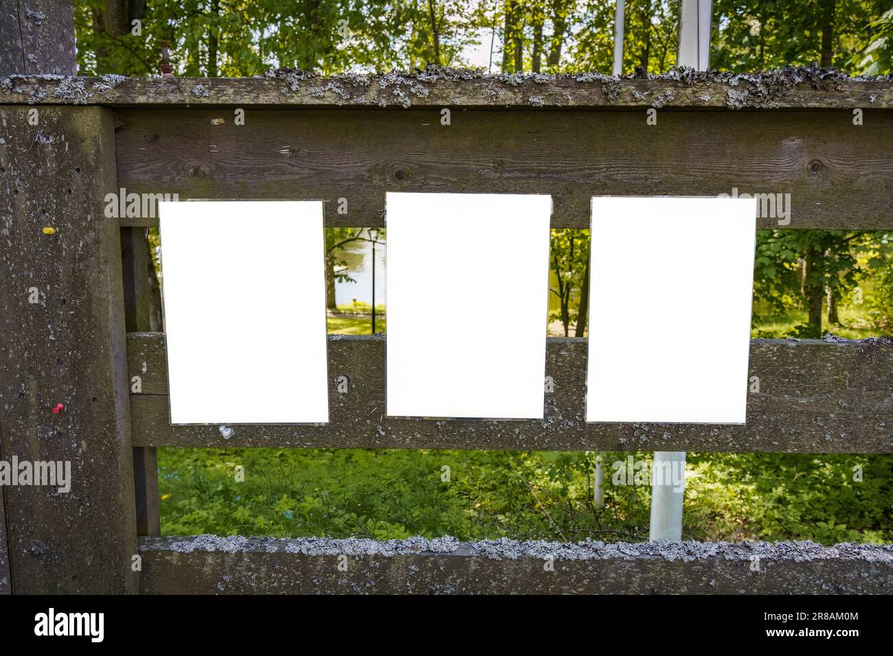 Trois notes blanches vides sur une vieille clôture en bois en été Banque D'Images