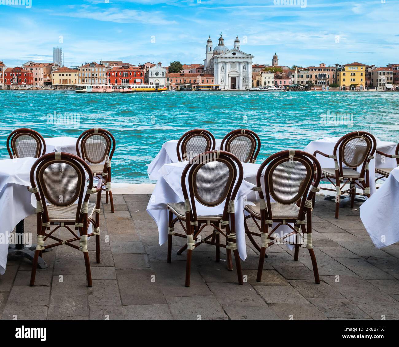 Tables et chaises en plein air un restaurant avec vue sur le canal à Venise, Italie. Banque D'Images