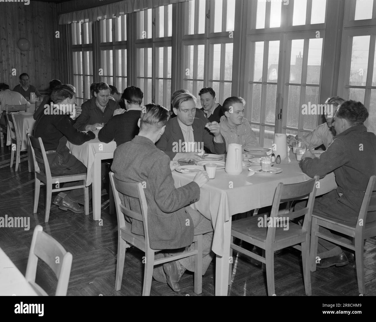 Actuel 2-1950: Plus dans une nouvelle vie le centre d'inscription pour le recyclage est le nom d'une institution qui a été établie dans ce pays en 1946. Une pénurie de main-d'œuvre après la guerre a créé un besoin pour l'emploi des personnes partiellement valides. Le centre d'inscription assure le recyclage, le financement et la mise en œuvre pratique des plans qu'ils ont mis en place pour chaque patient individuel. Certains des gars du service d'enregistrement mangent le déjeuner dans la salle à manger lumineuse et agréable. La plupart d'entre eux sont au centre d'inscription depuis quelques mois et sont aidés dans le pro Banque D'Images