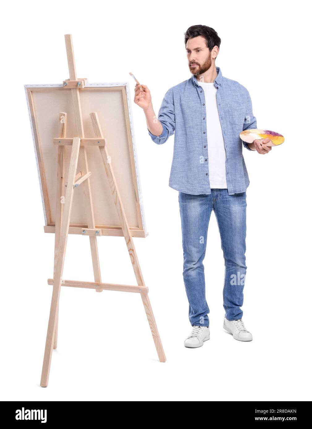 Homme peint sur fond blanc. Utilisation du chevalet pour tenir la toile Banque D'Images