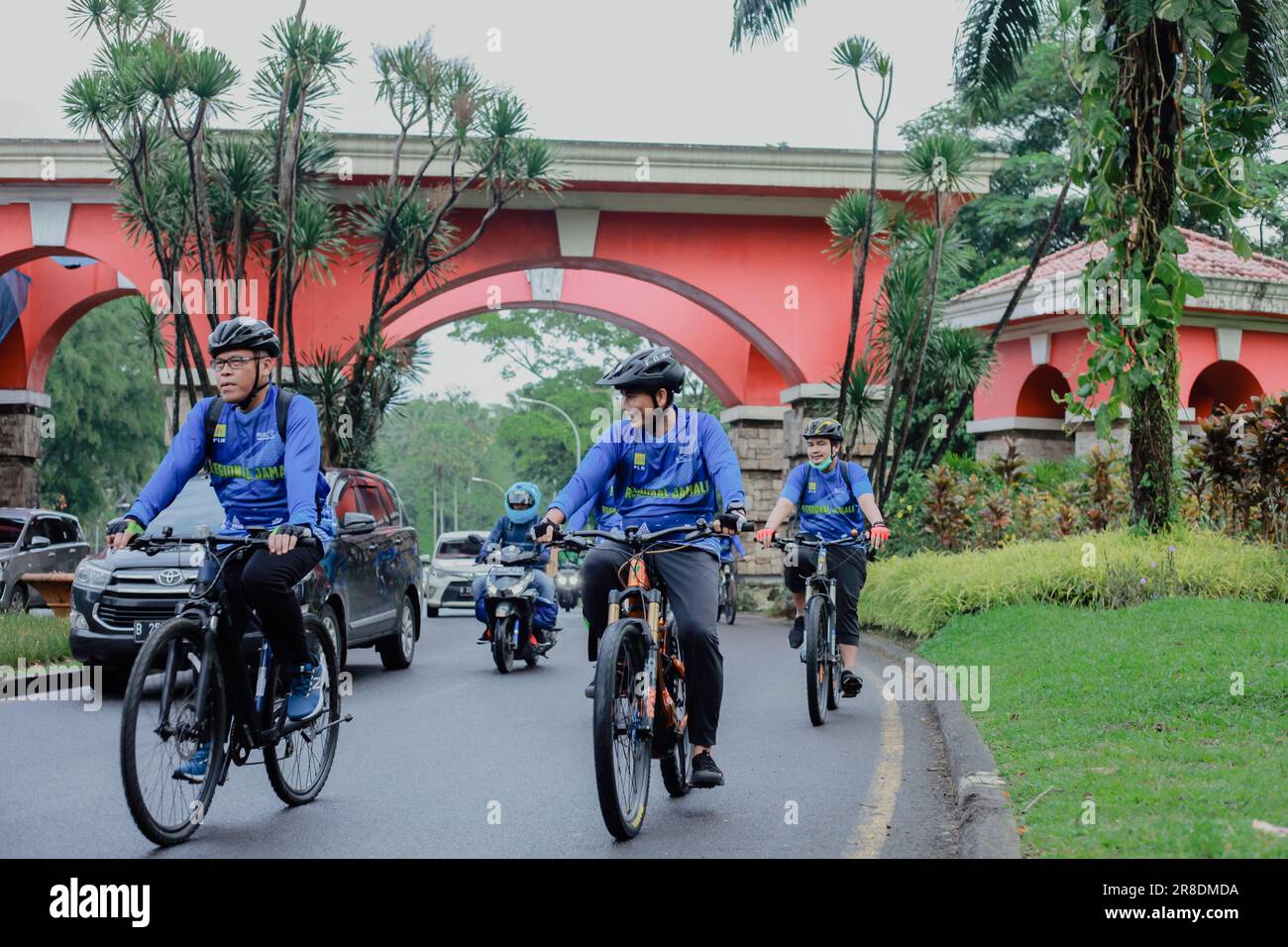 Un groupe d'hommes asiatiques en chemises bleues et portant des casques sont très excités de faire leurs activités de cyclisme un jour de congé par un matin ensoleillé Banque D'Images