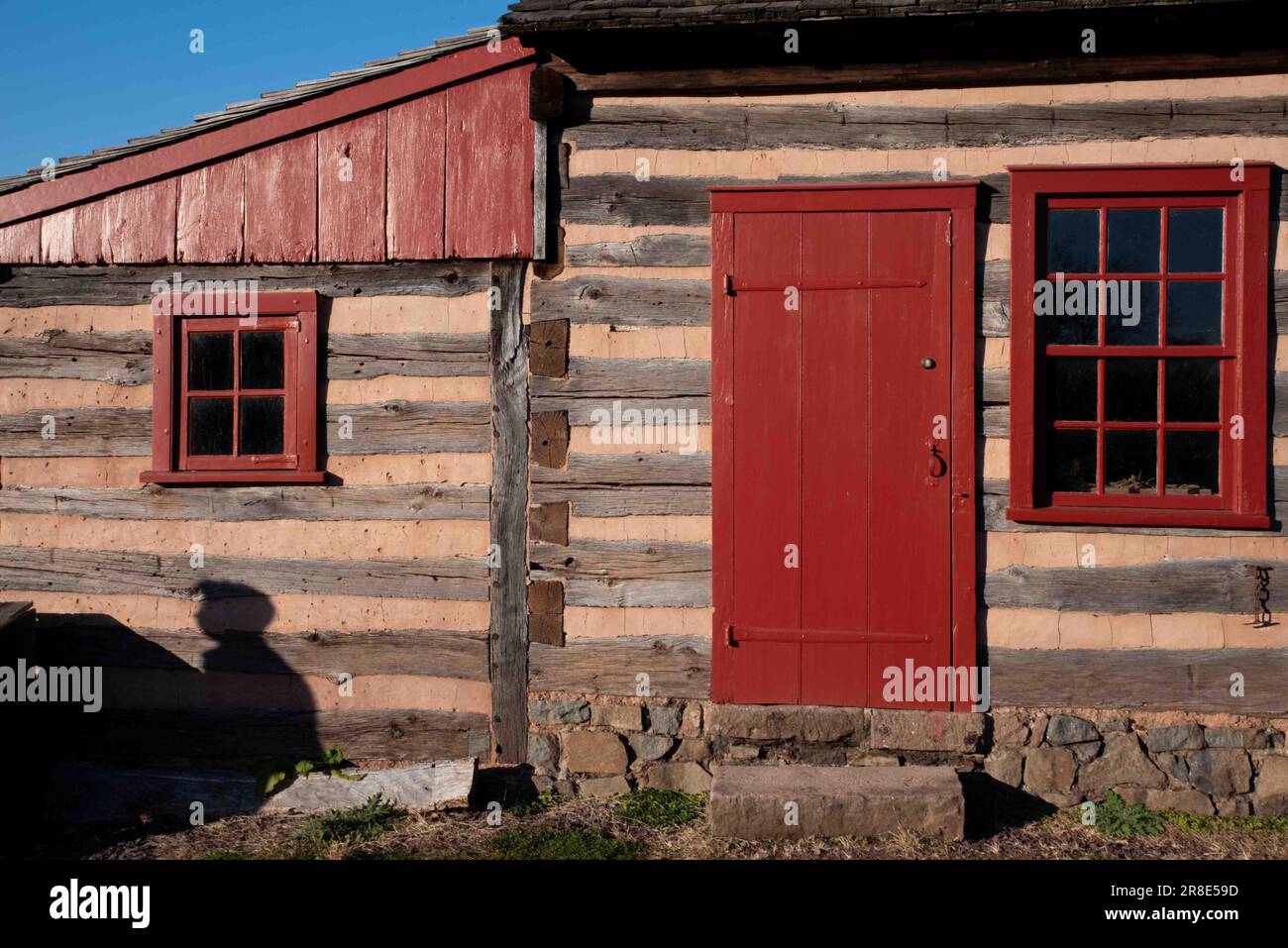Gros plan de l'extérieur de la cabine en rondins de Pennsylvanie avec fenêtre et porte rouges Banque D'Images