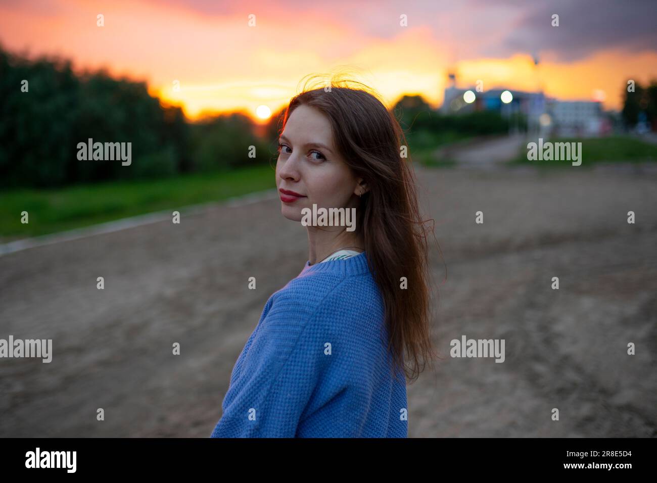 Portrait de belle femme debout dans le champ au coucher du soleil Banque D'Images