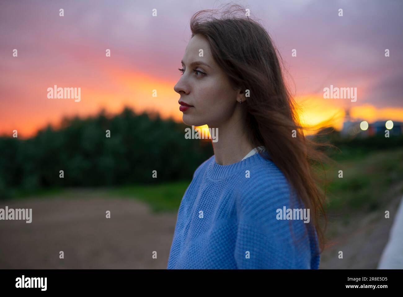 Portrait de belle femme debout dans le champ au coucher du soleil Banque D'Images
