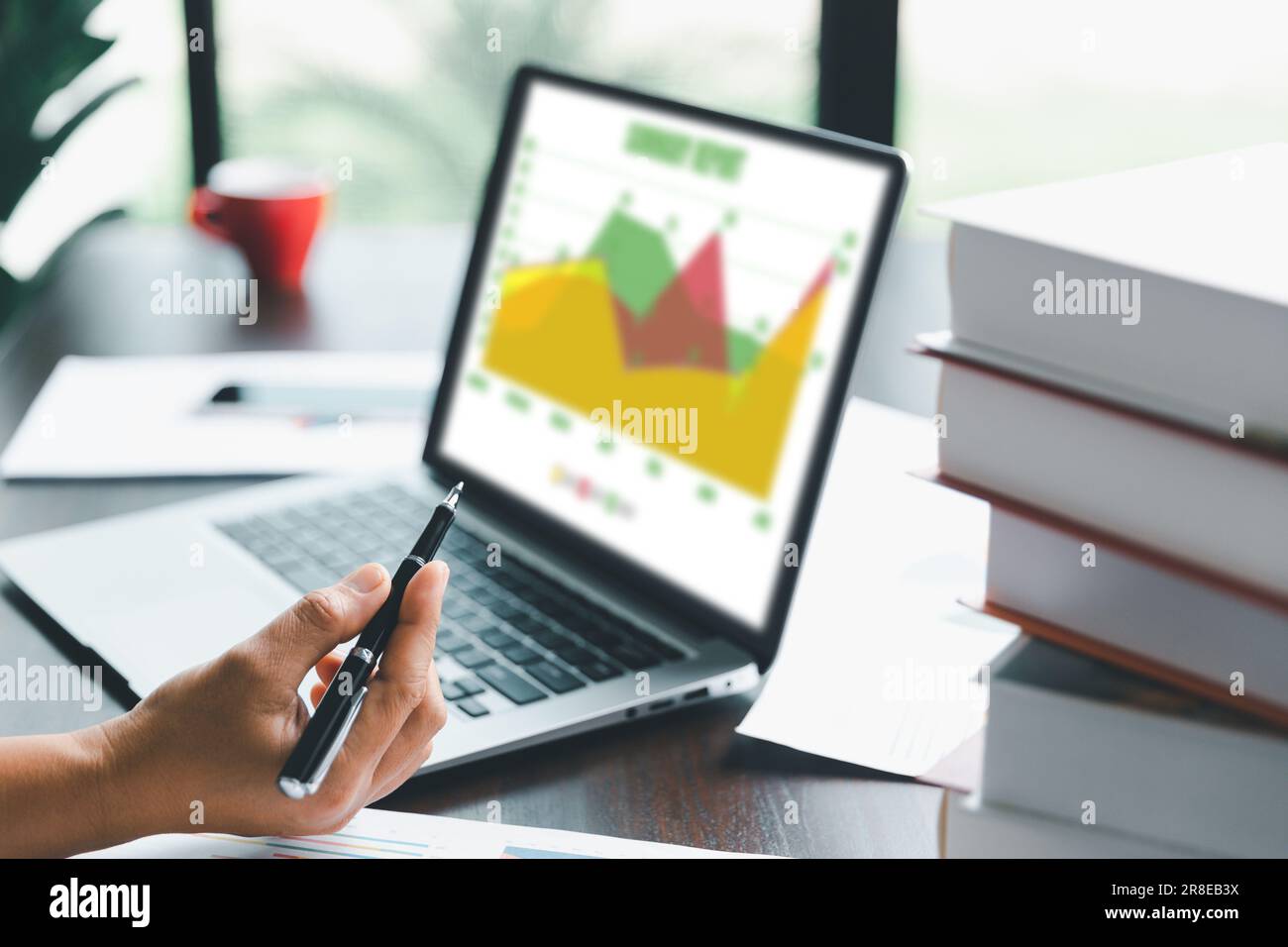 Une jeune femme de garde bancaire utilisant une calculatrice, un ordinateur portable, une feuille de travail papier pour analyser les informations de données. Elle est une financière professionnelle de ba Banque D'Images