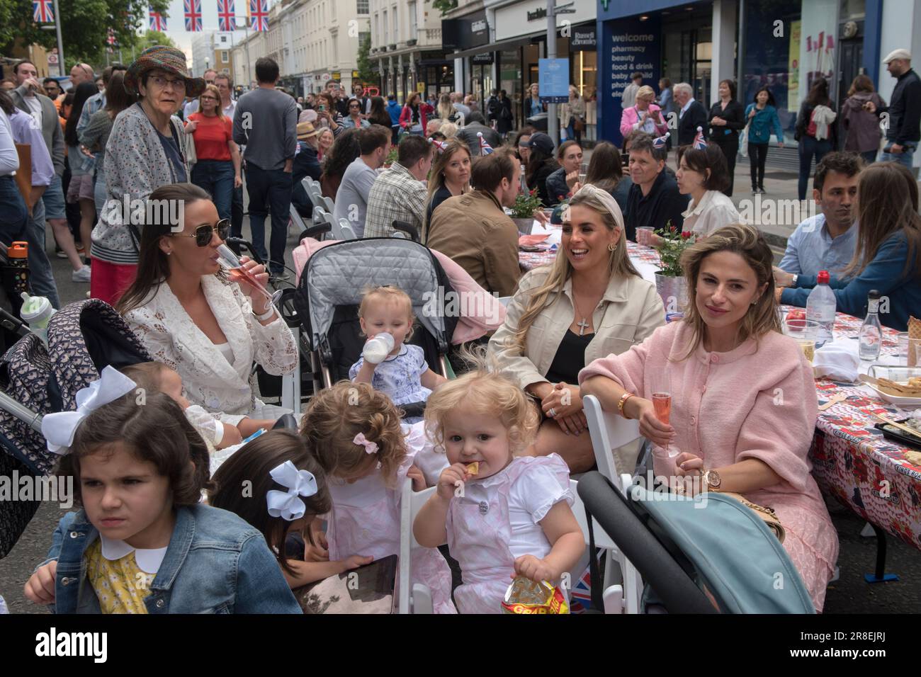 Chelsea, Londres, Angleterre 4 juin 2022. Le Kings Road, Platinum Jubilee Street Party, qui soutient l'appel de crise de la Croix-Rouge britannique en Ukraine. La Kings Road est en partie fermée à la circulation, des tables descendent au centre de la route, des stands de nourriture sont mis en place et font de bonnes affaires. Les jeunes adultes de Chelsea et Knightsbridge, les momies délicieuses avec leurs enfants discutent et boivent du champagne. ANNÉES 2020 ROYAUME-UNI HOMER SYKES Banque D'Images