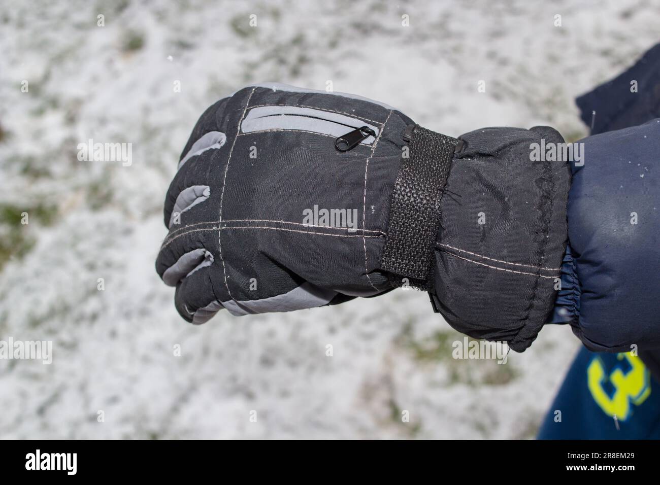 les mains du garçon sont vêtues de gants d'hiver chauds Banque D'Images