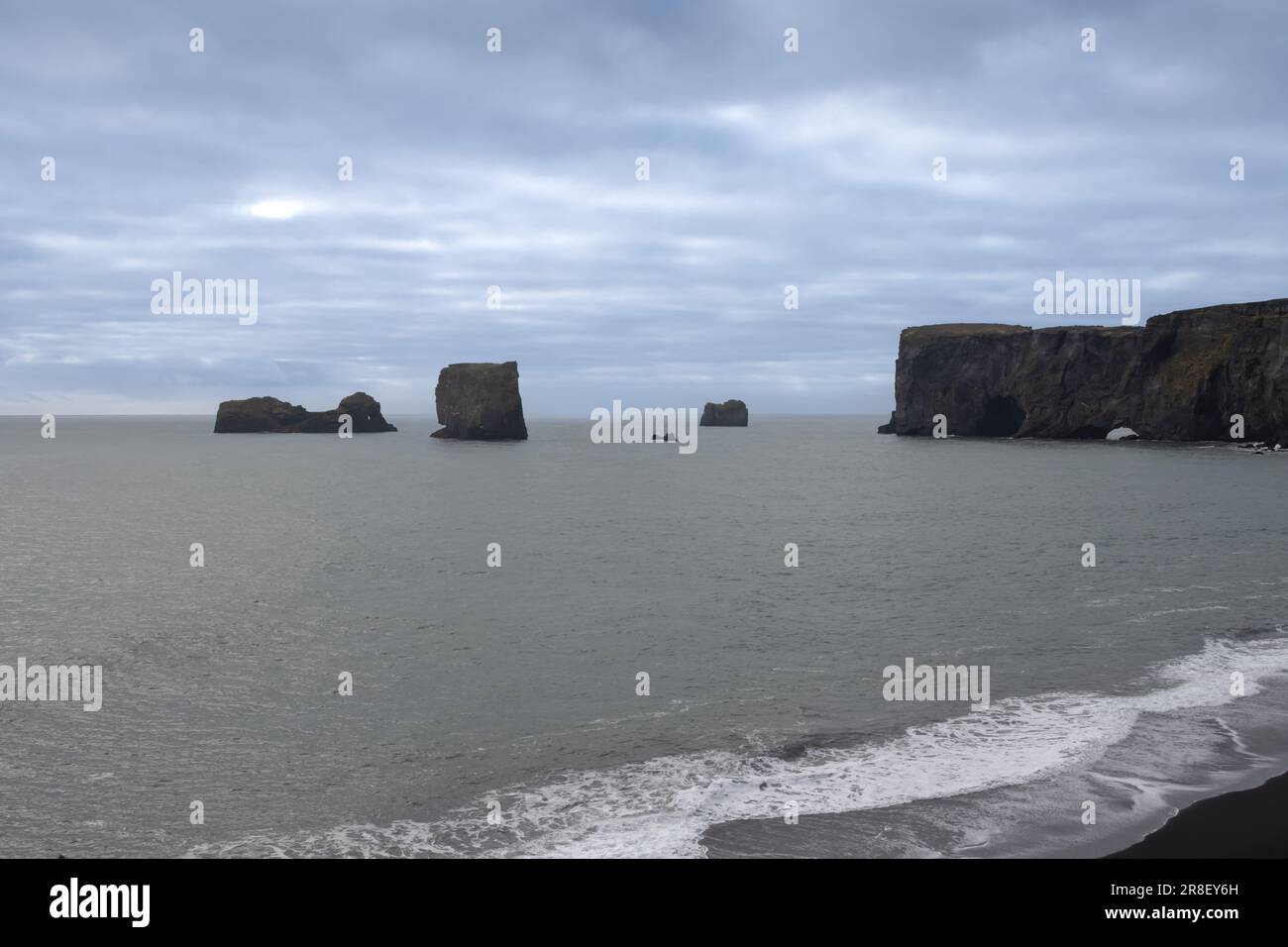 Côte de l'océan Atlantique au sud de l'île. Célèbre plage de sable noir avec ses formations rocheuses. Ciel nuageux en automne. Reynisfja Banque D'Images