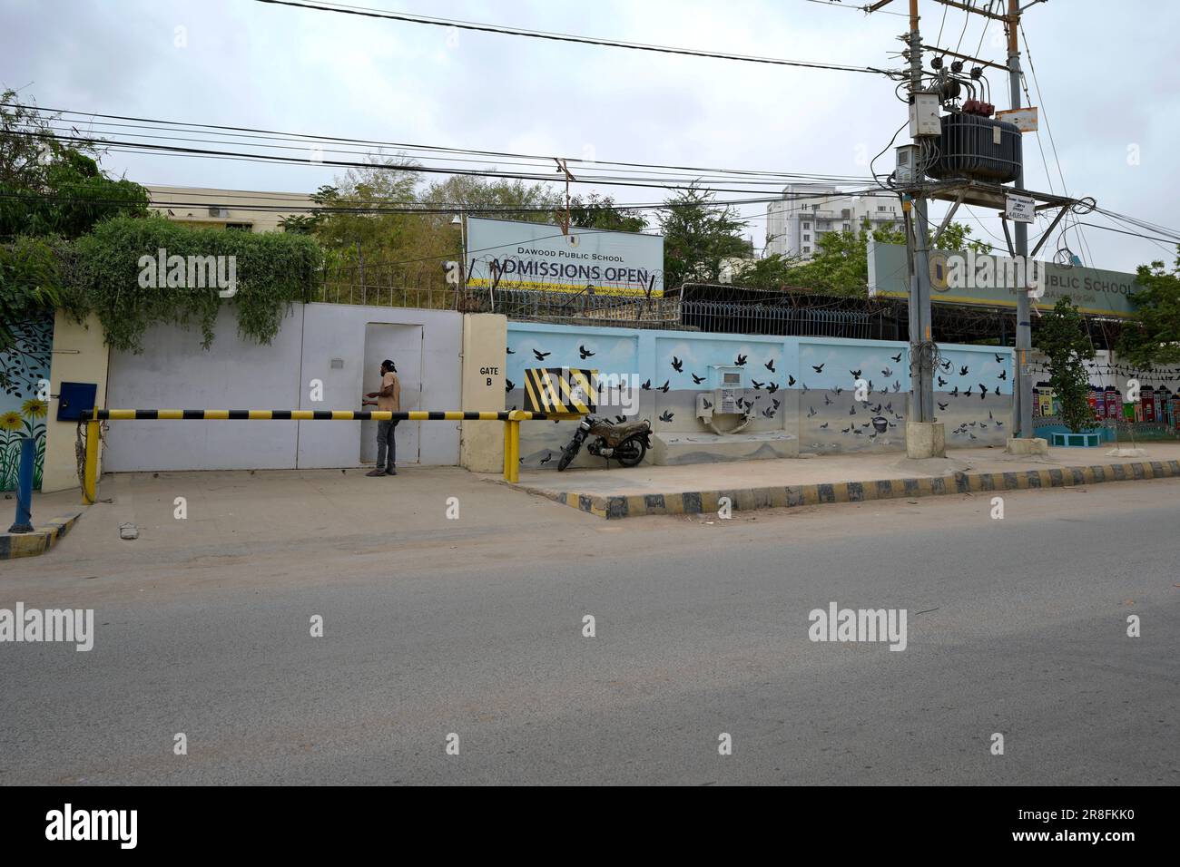 A Man Stands At The Gate Of Dawood Public School A Trust Owned a-man-stands-at-the-gate-of-dawood-public-school-a-trust-owned