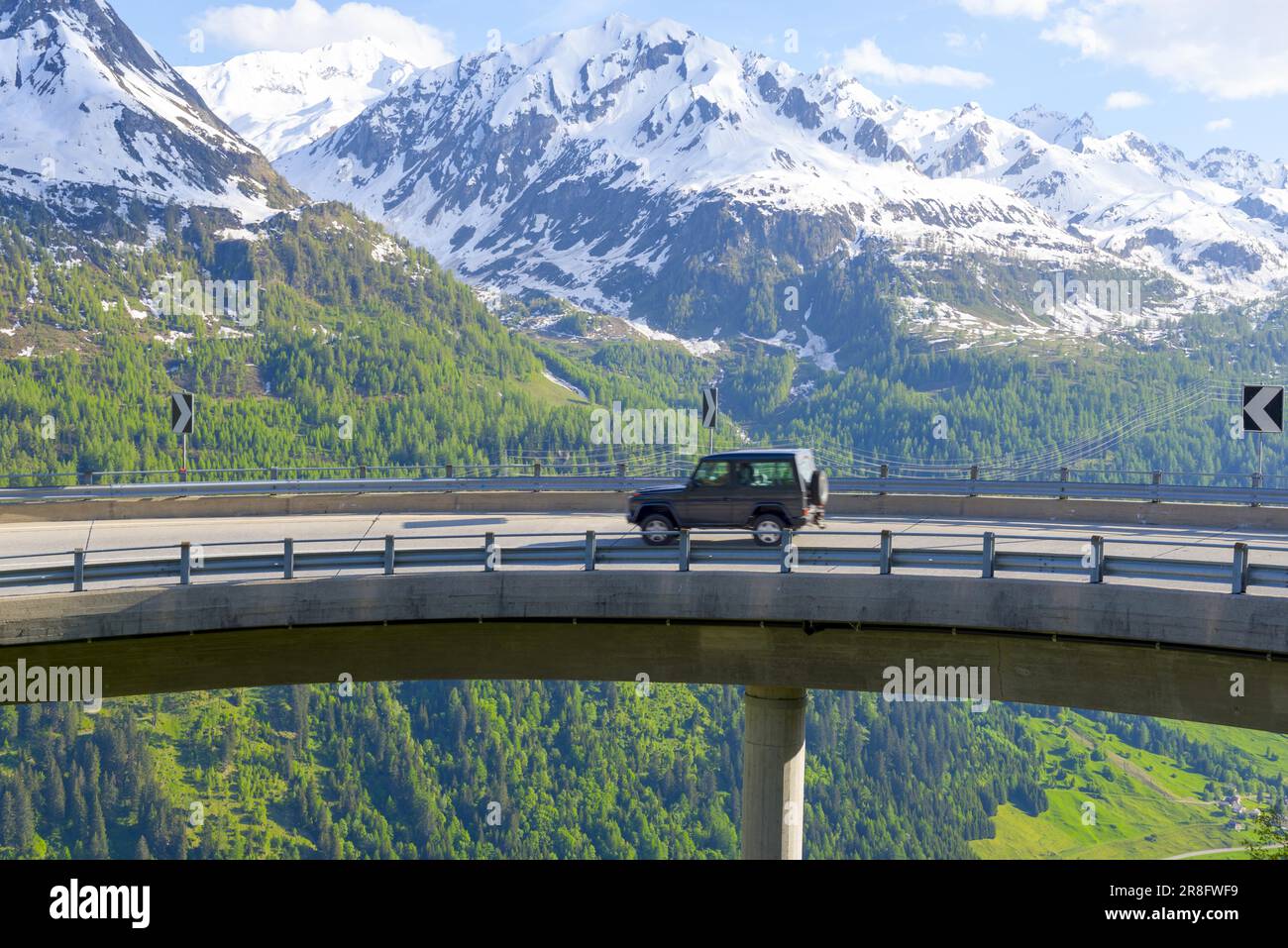 Voiture sur une route de montagne avec montagne enneigée en Suisse Banque D'Images