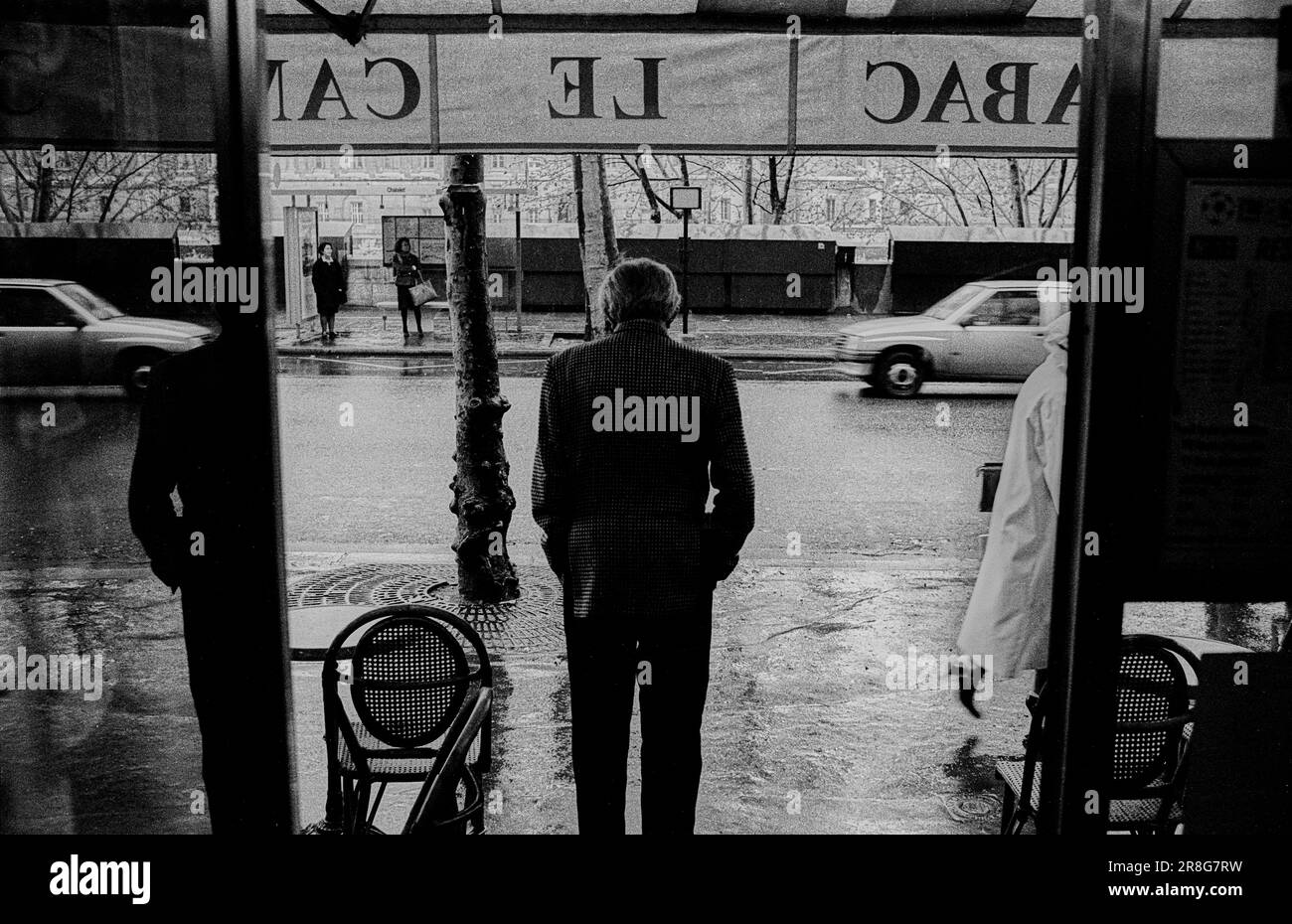 France, Paris, 22.03.1990, homme devant un restaurant, jour de pluie Banque D'Images