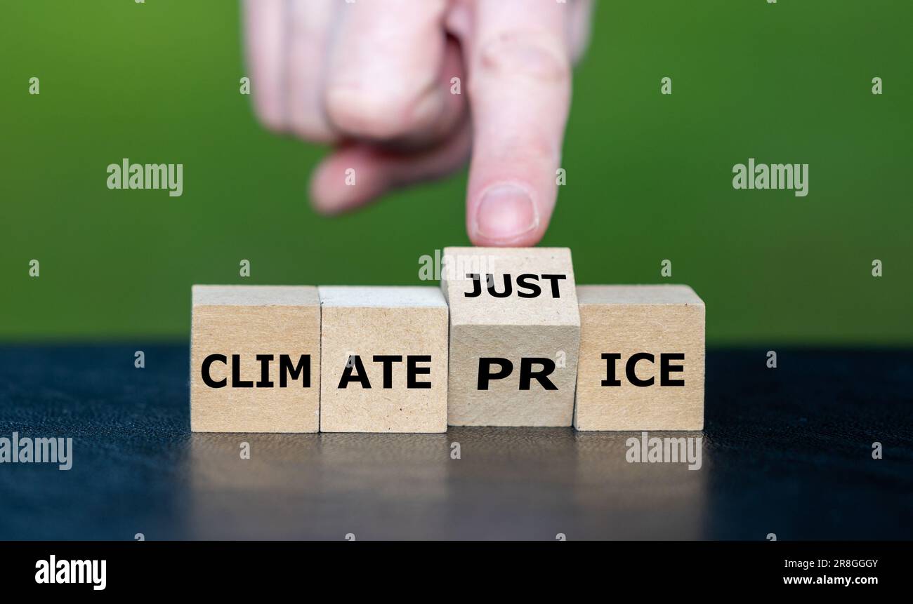 La main transforme le cube en bois et transforme l'expression « prix climatique » en « justice climatique ». Banque D'Images