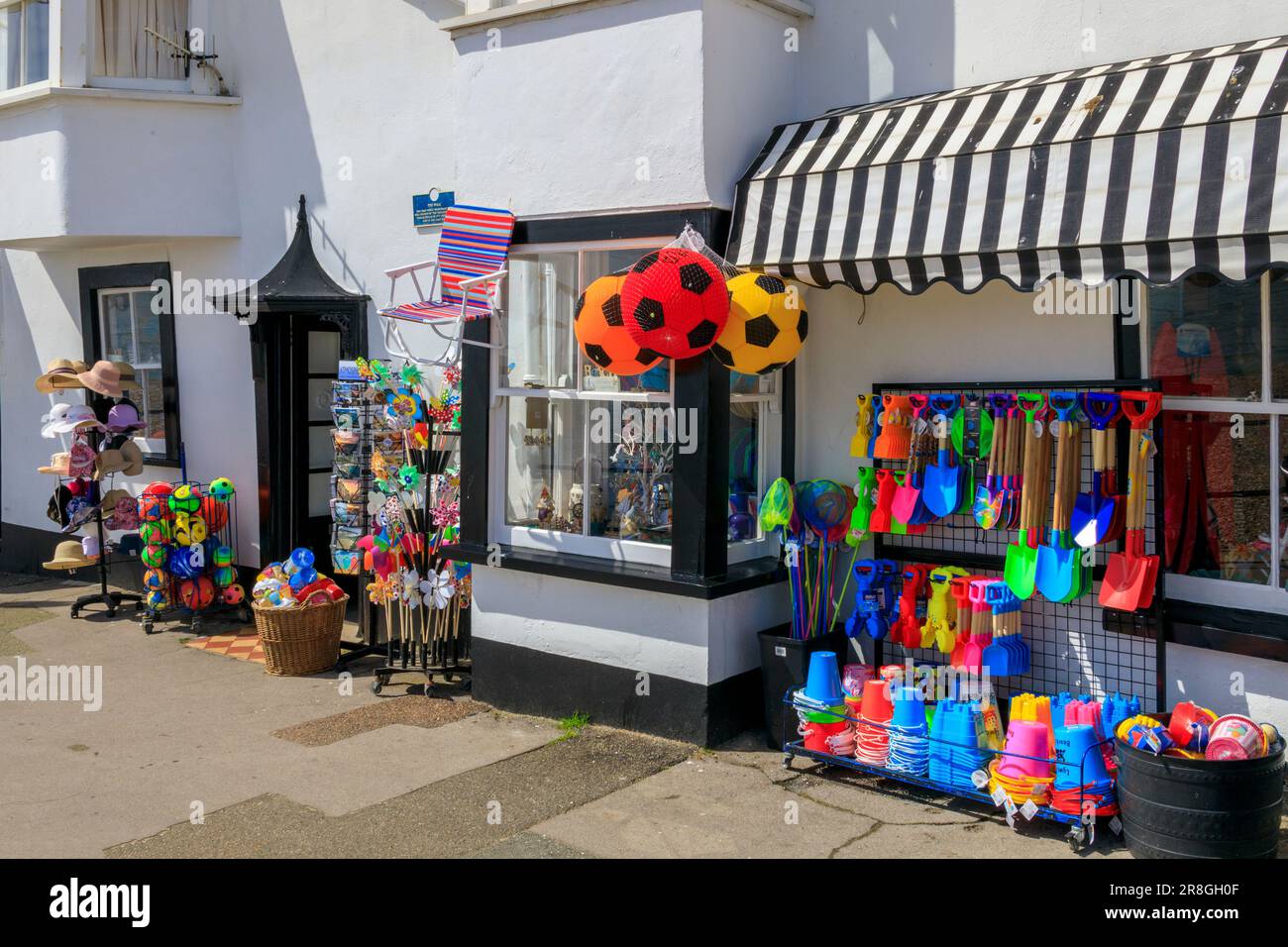 Une boutique vendant des paraphernalia de plage colorés - seaux, spades, balles etc à Lyme Regis sur la côte jurassique, Dorset, Angleterre, Royaume-Uni Banque D'Images