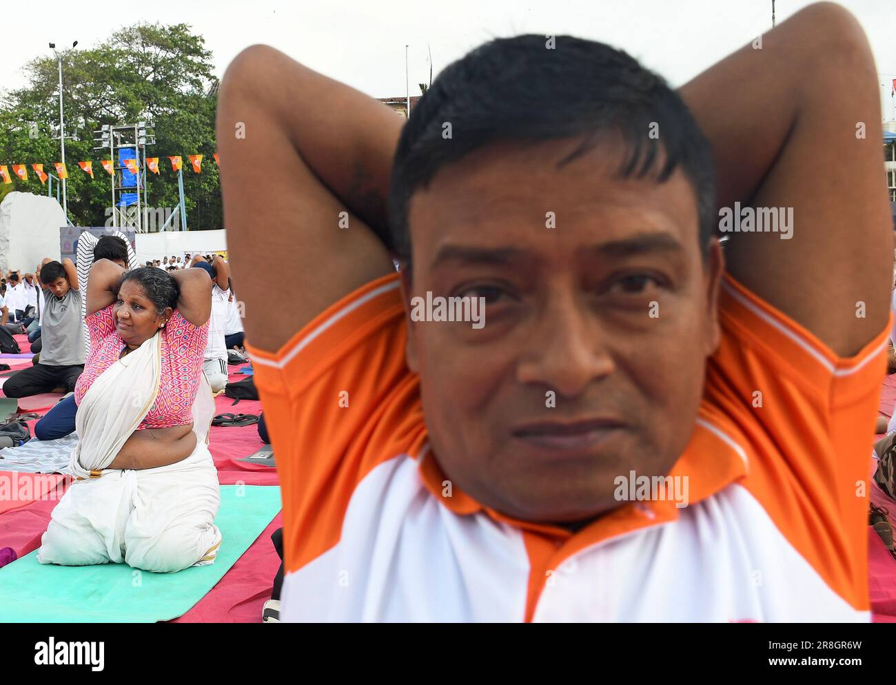 Une femme (en arrière-plan) portant une saree effectue un exercice de yoga tout en étant assise sur un tapis à la porte de l'Inde à l'occasion de la Journée internationale du yoga à Mumbai. 9th la Journée internationale du yoga a été célébrée le 21st juin 2023 dans le monde entier. Le thème de la journée de yoga était 'Vasudhaiva Kutumbakam' une phrase sanskrit signifiant 'le monde entier est une famille' (photo par Ashish Vaishnav / SOPA Images/Sipa USA) Banque D'Images