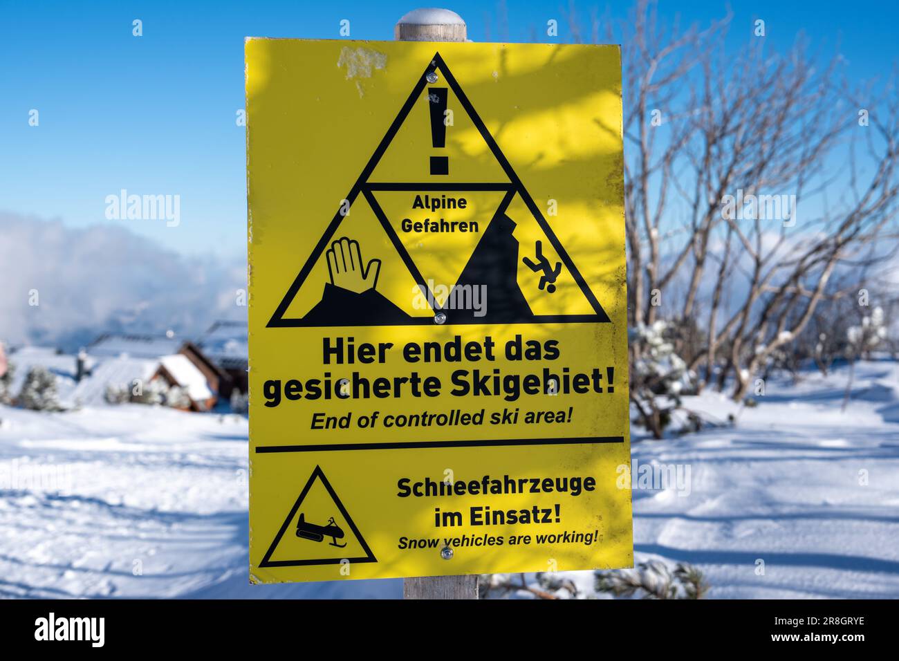 Un panneau d'avertissement jaune est affiché sur le côté d'une montagne rocheuse enneigée en Allemagne Banque D'Images