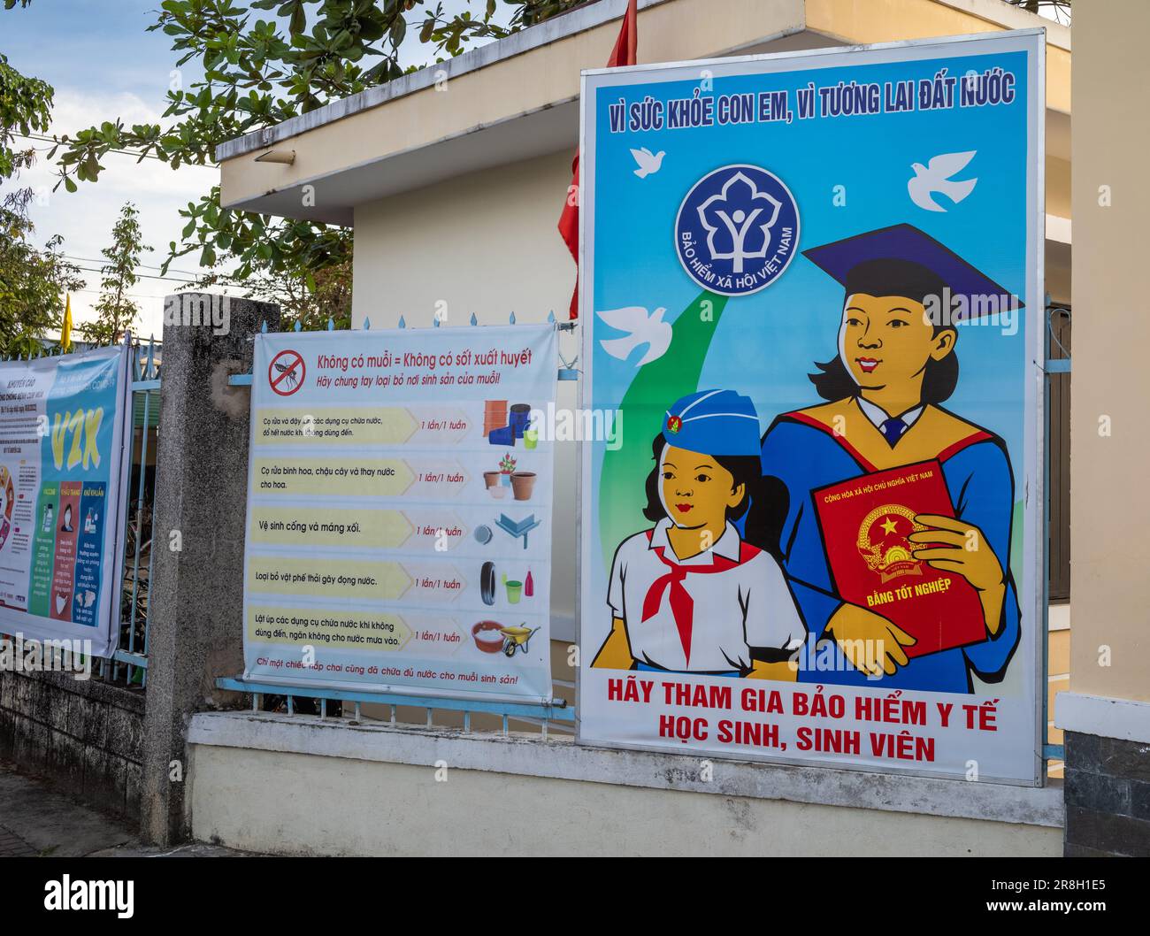Affiches publicitaires et de propagande exposées à l'extérieur d'une école secondaire à Kontum, dans les Hautes-terres centrales du Vietnam. L'affiche de gauche avertit Banque D'Images